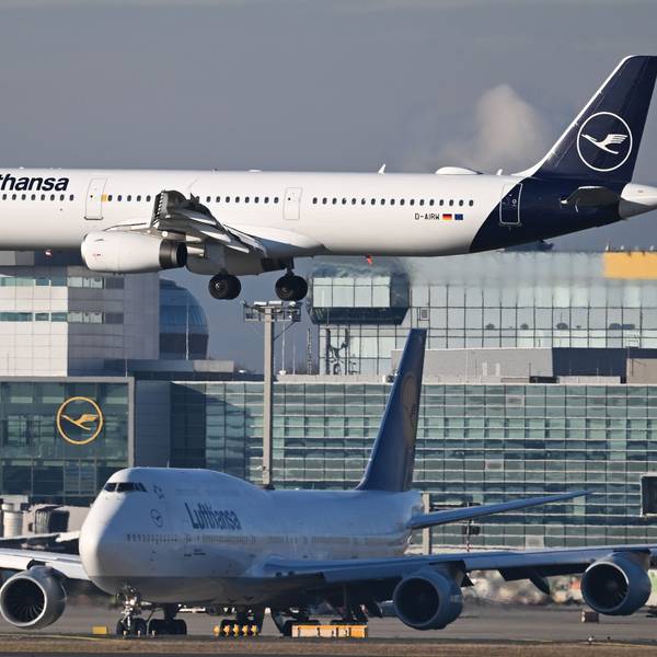 Ein Lufthansa Airbus A321-100 landet am Frankfurter Flughafen, während eine Lufthansa Boeing 747 vor der Startbahn warten muss.