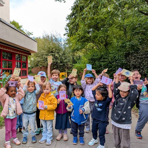 Die Kinder zeigen die Postkarten, die sie an Mitglieder des Jugendhilfausschusses geschrieben haben.