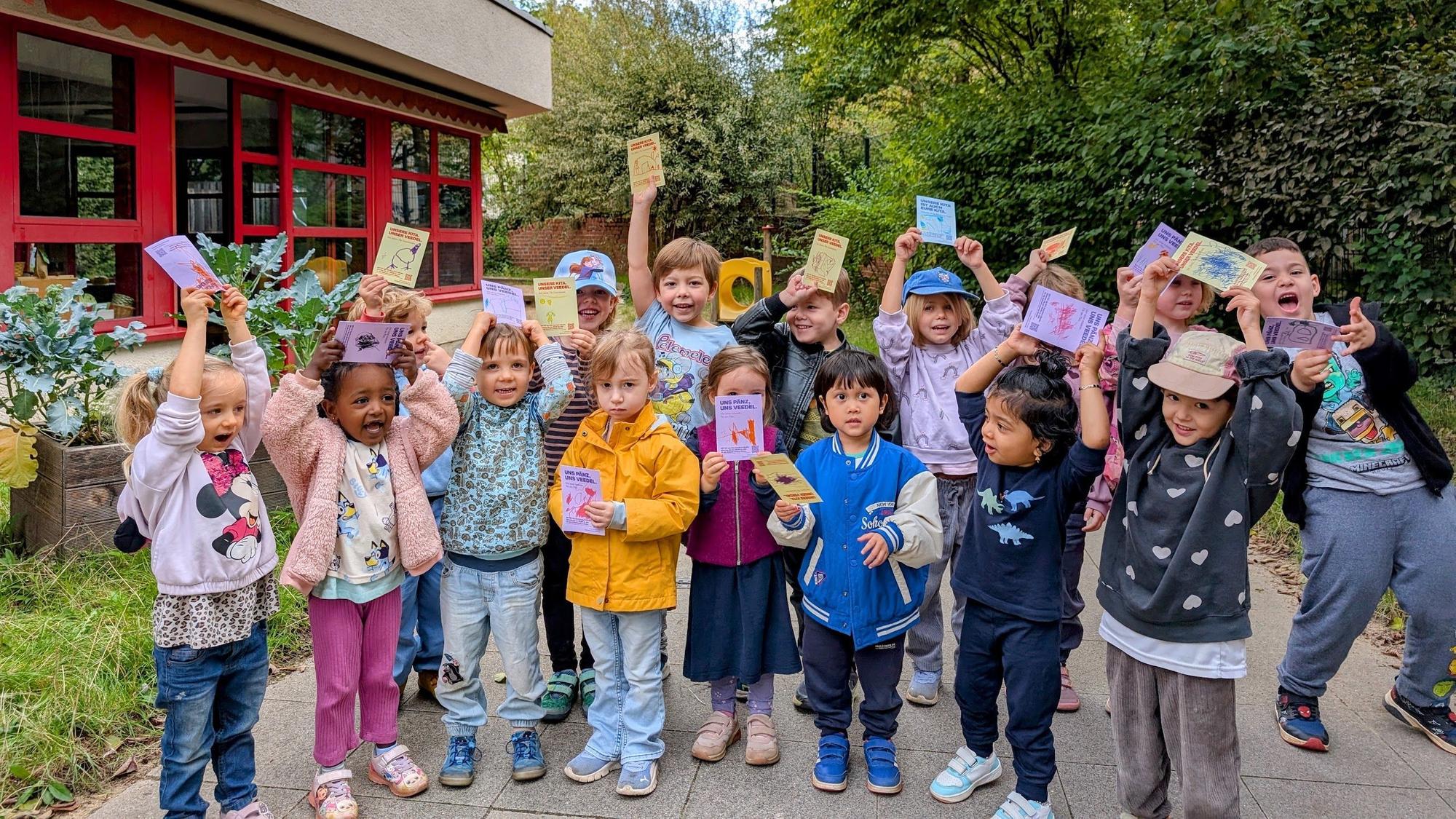 Die Kinder zeigen die Postkarten, die sie an Mitglieder des Jugendhilfausschusses geschrieben haben.