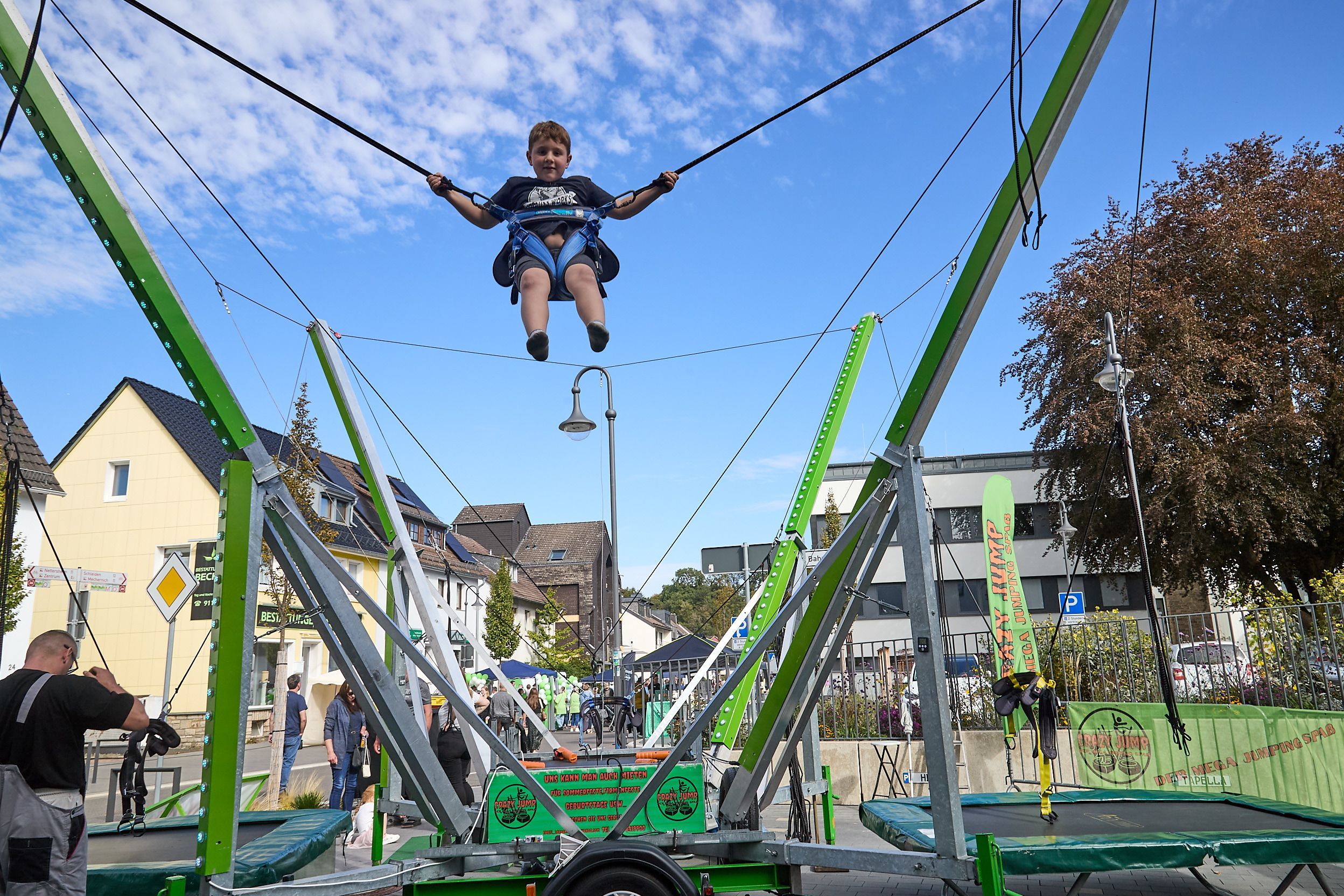 Ein Junge hängt an einem Seil in einem Trampolinparcours.
