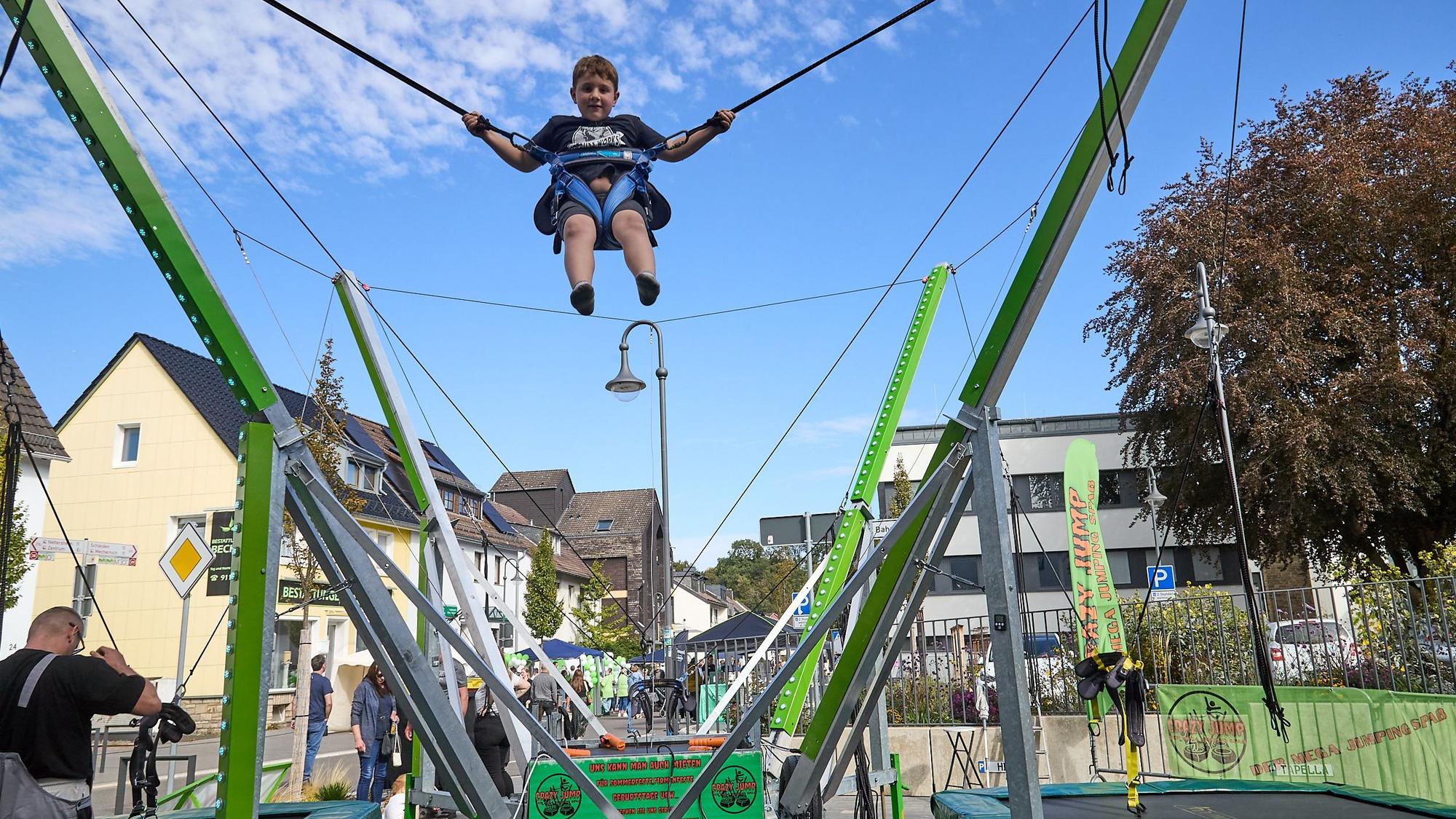 Ein Junge hängt an einem Seil in einem Trampolinparcours.