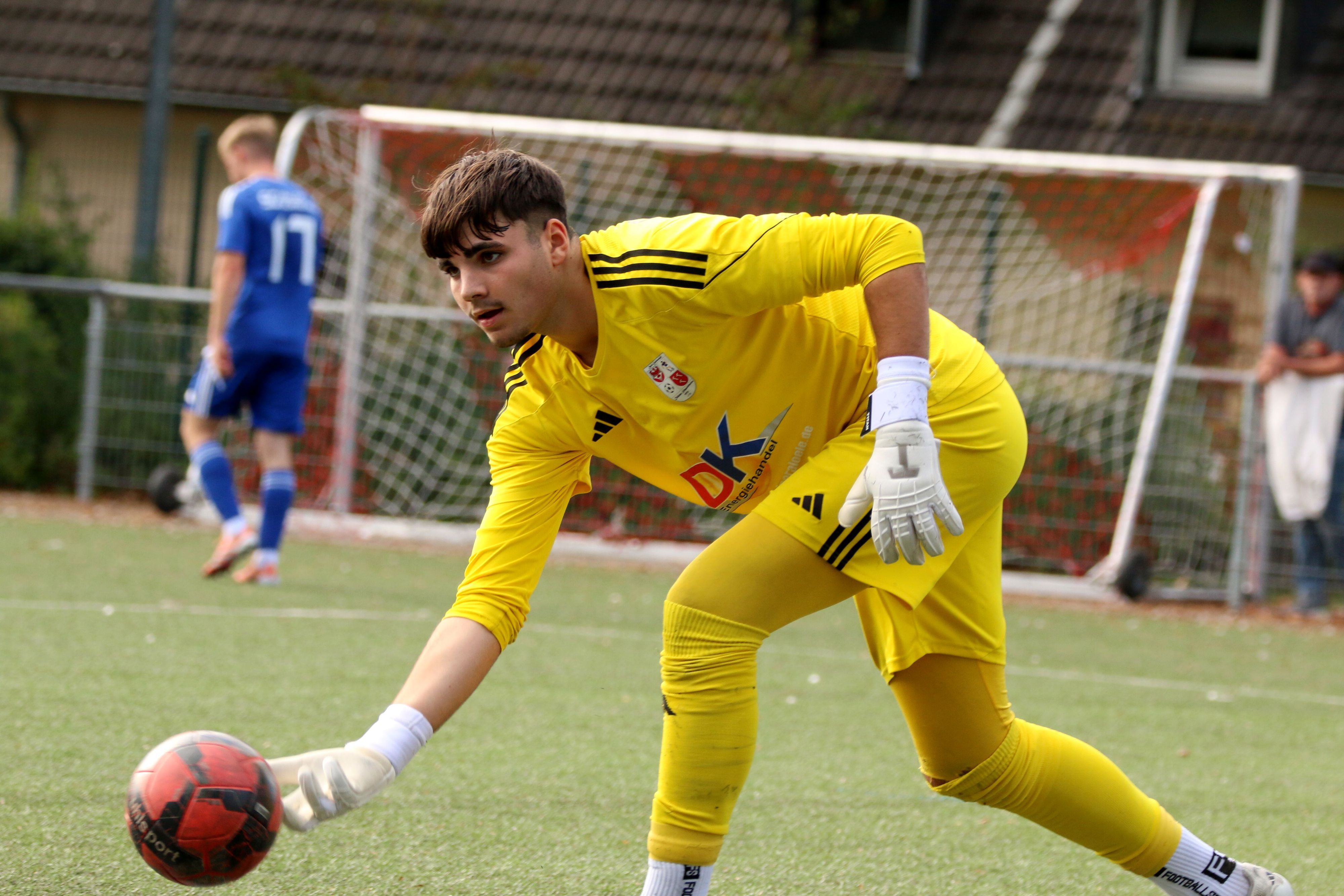 Dahlems Torwart rollt einen Ball ein.