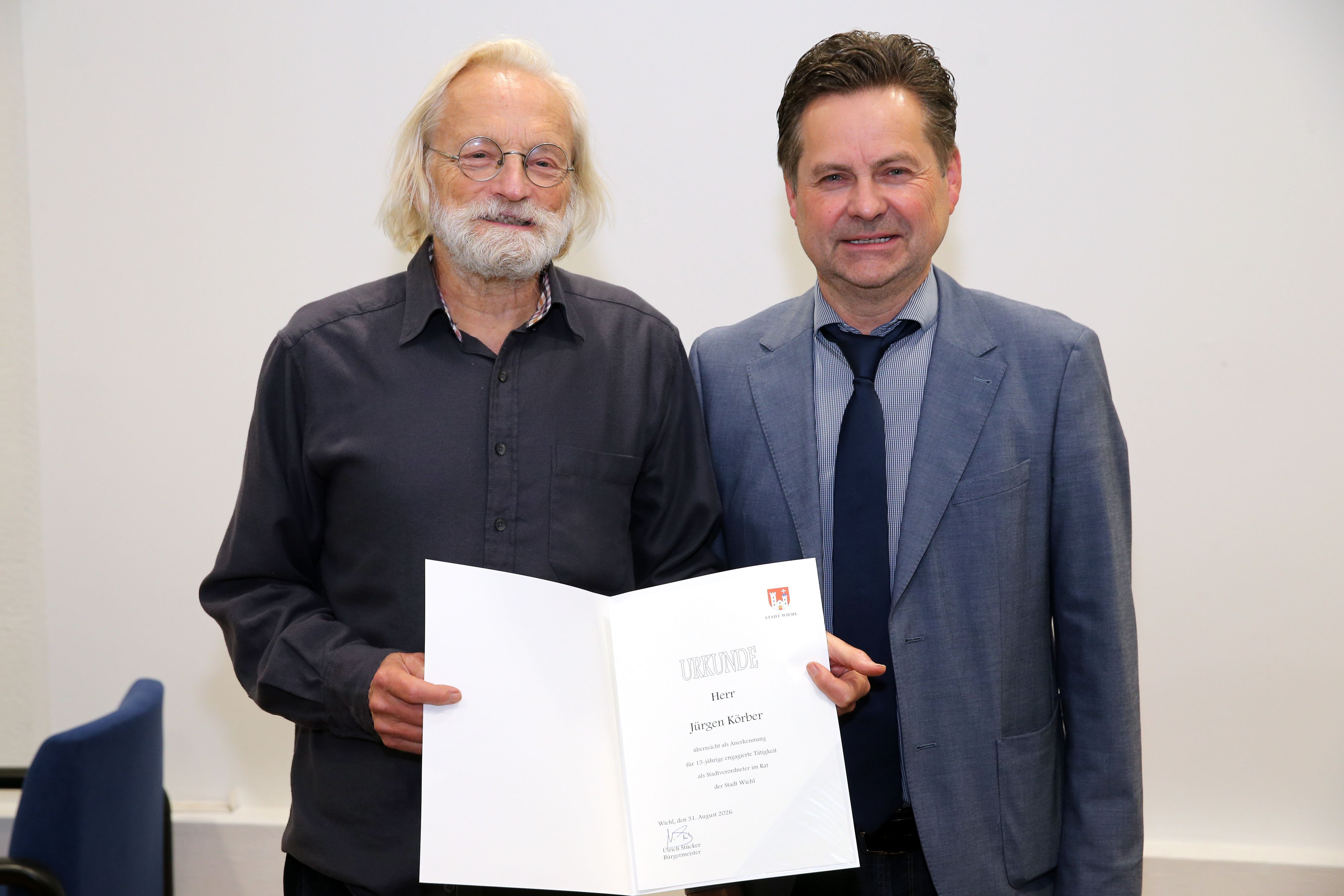 Zwei Herren mit Urkunde.