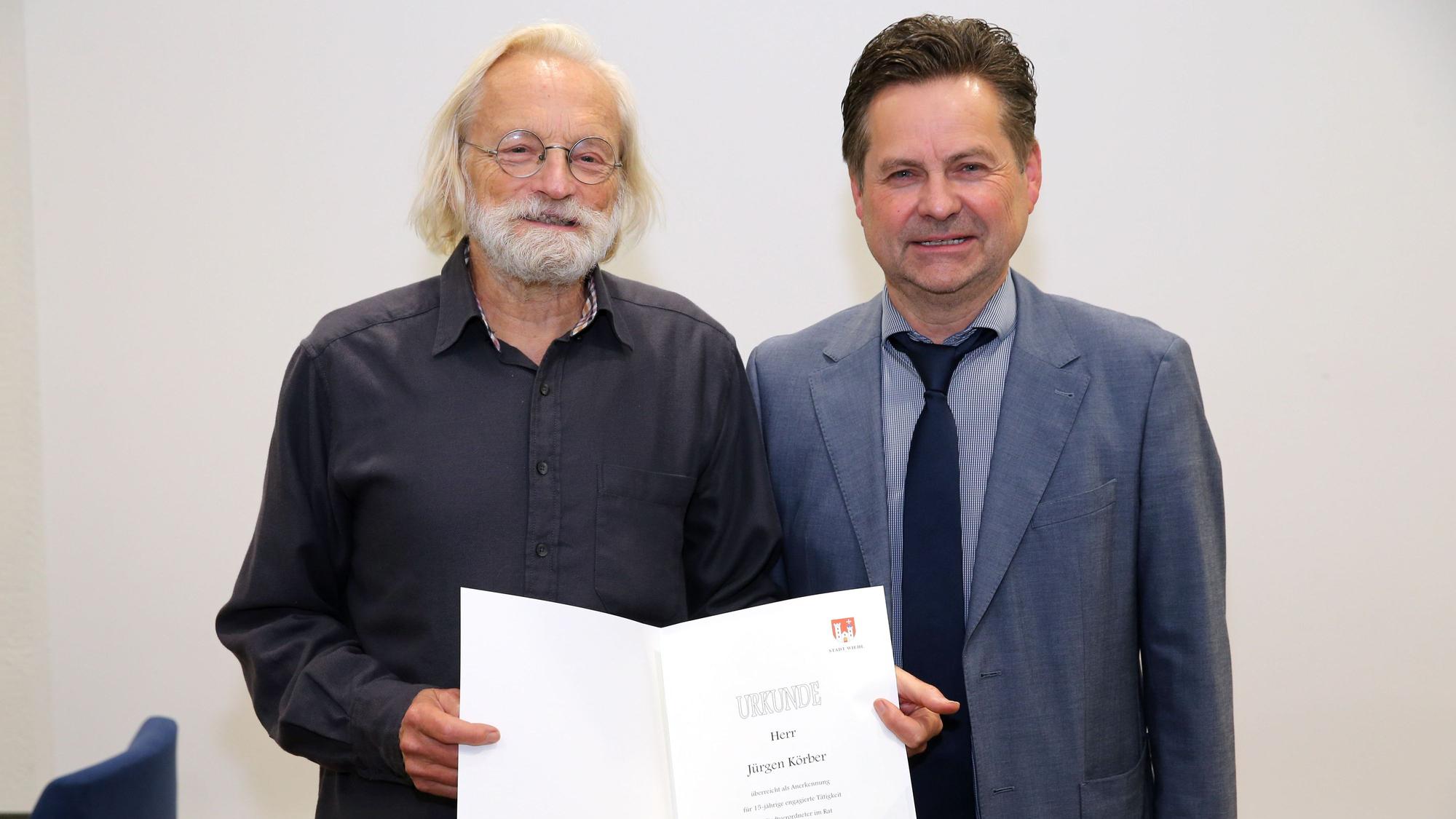 Zwei Herren mit Urkunde.