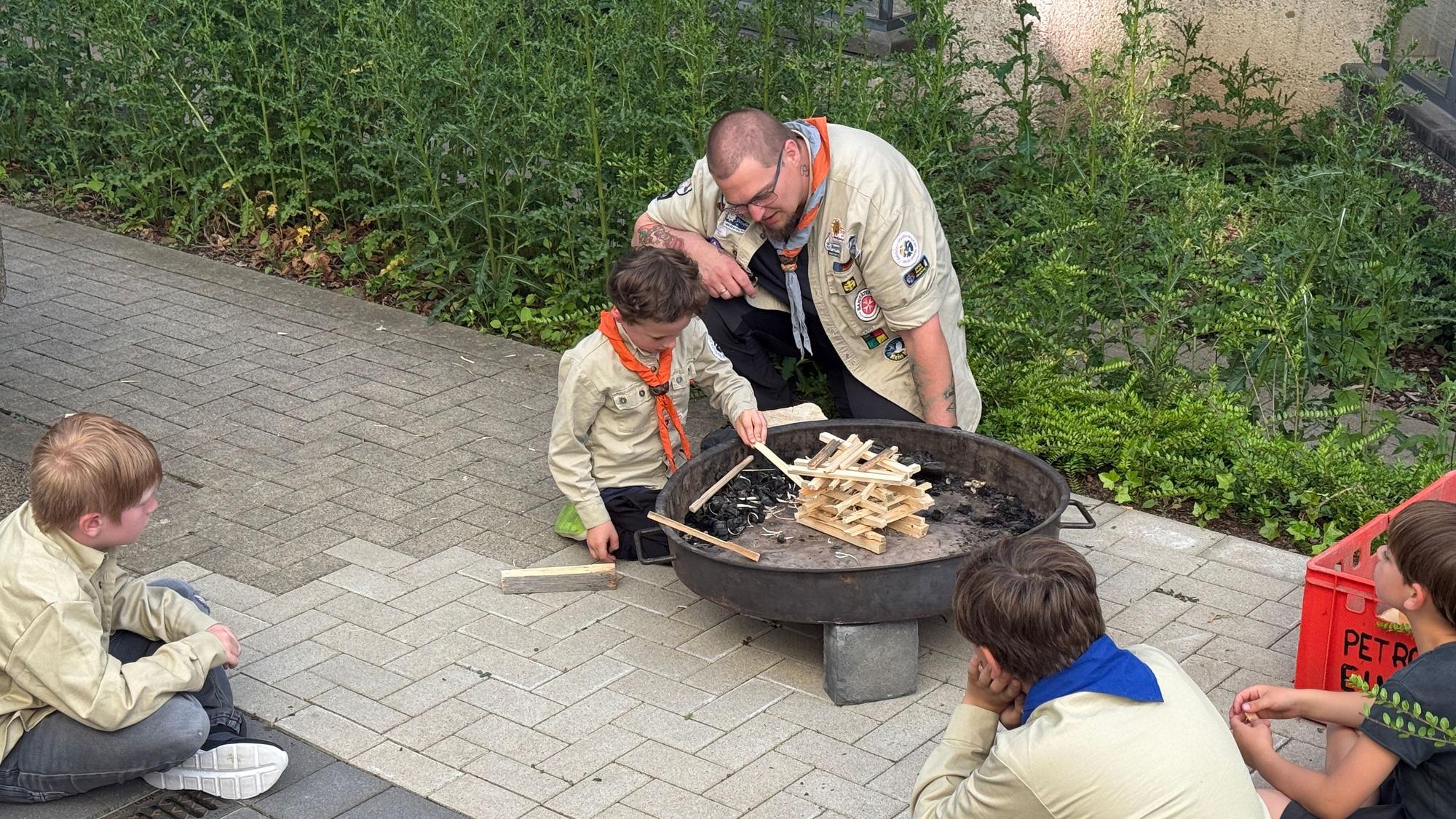 Der sechsjährige Leo probiert aus, was ihm Wölflingsleiter Jan Janitza gezeigt hat – wie man ohne Feuerzeug ein Feuer entfachen kann.