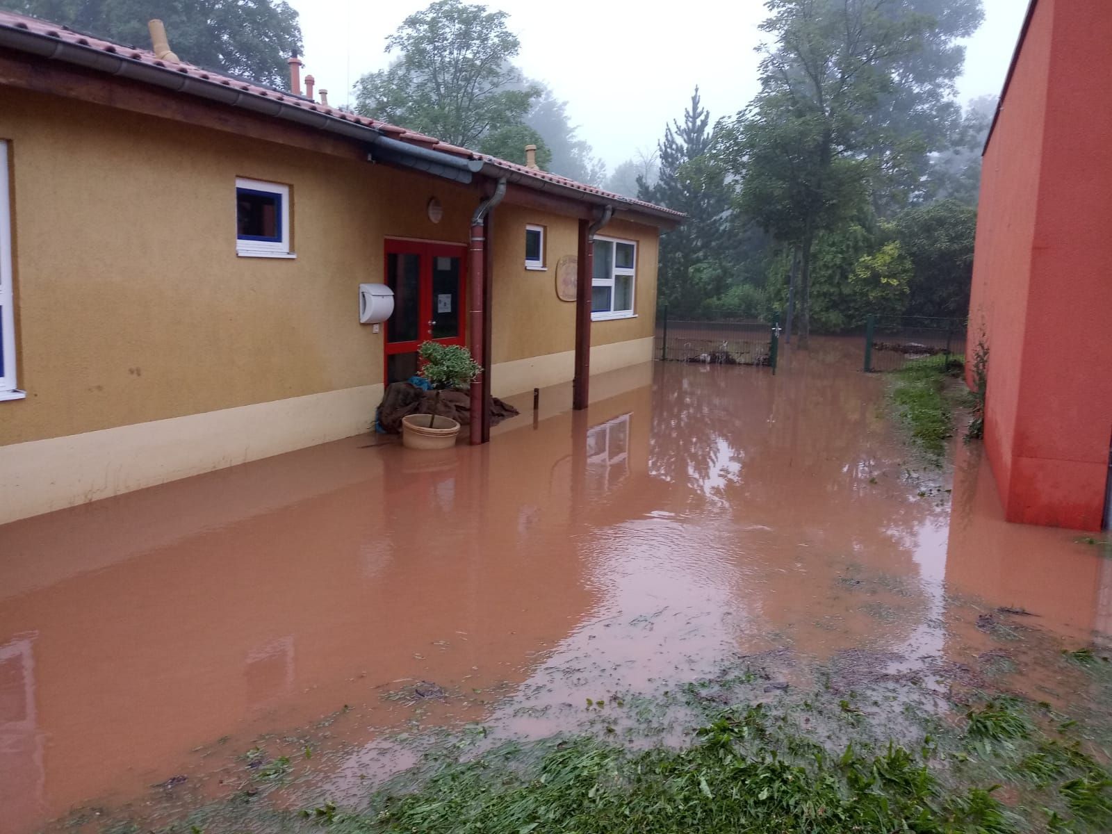Bei der Flutkatastrophe 2021 ist ein Gebäude vom schlammigen Wasser umgeben.