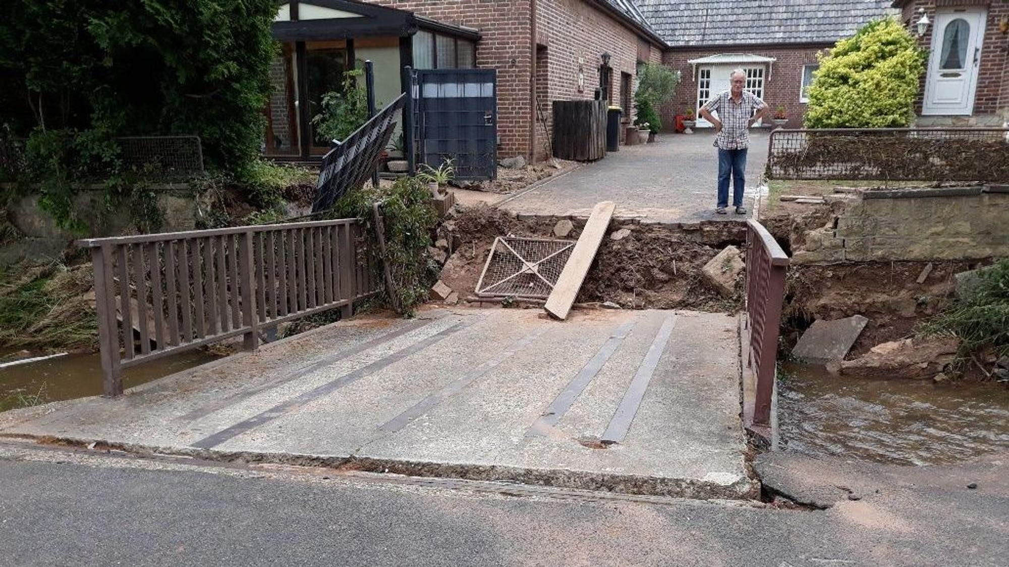 Eine Frau schaut auf eine zerstörte Brücke.