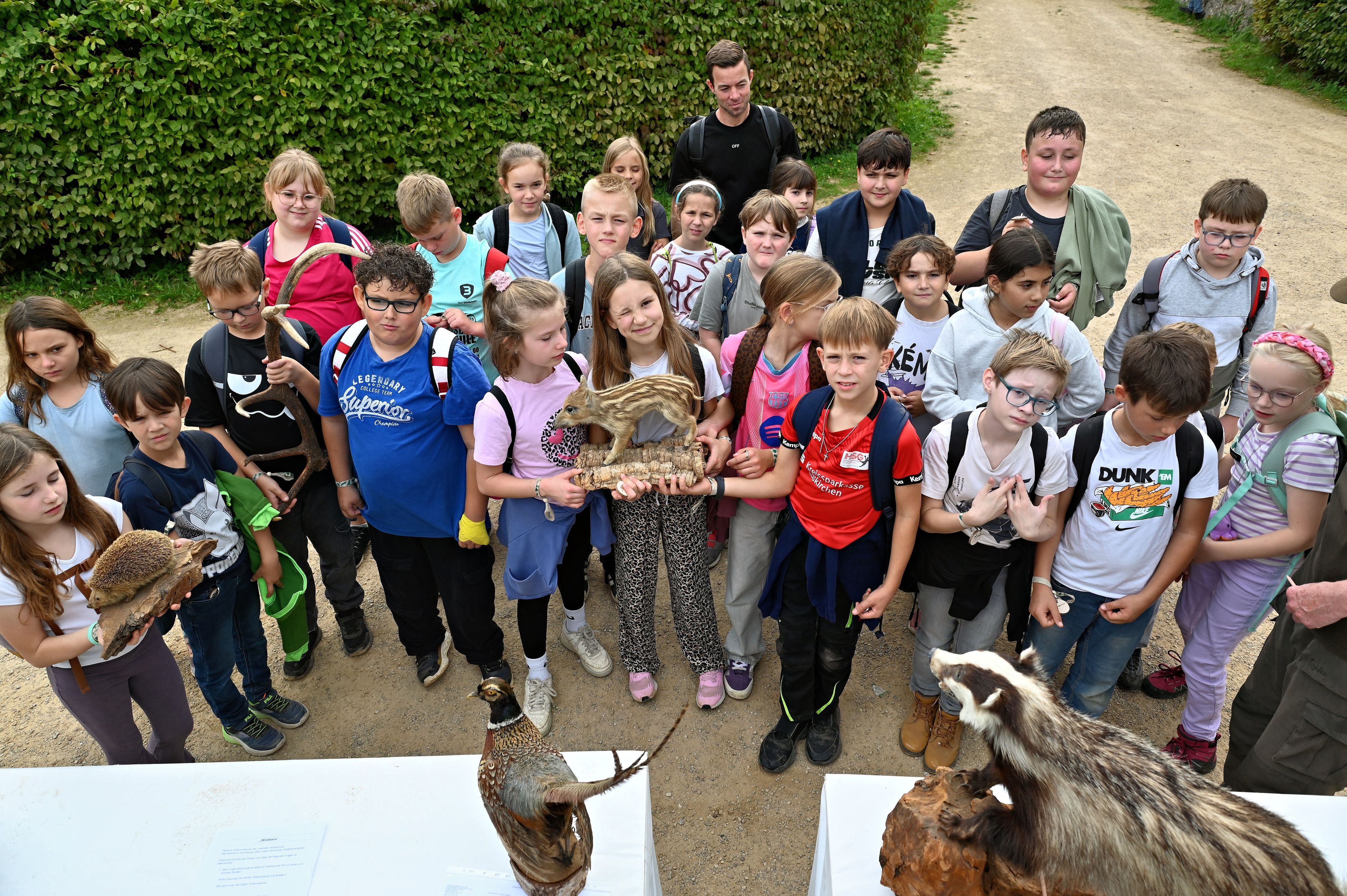 Einige der Kinder halten Tierpräparate in der Hand, etwa einen Igel und einen Frischling.