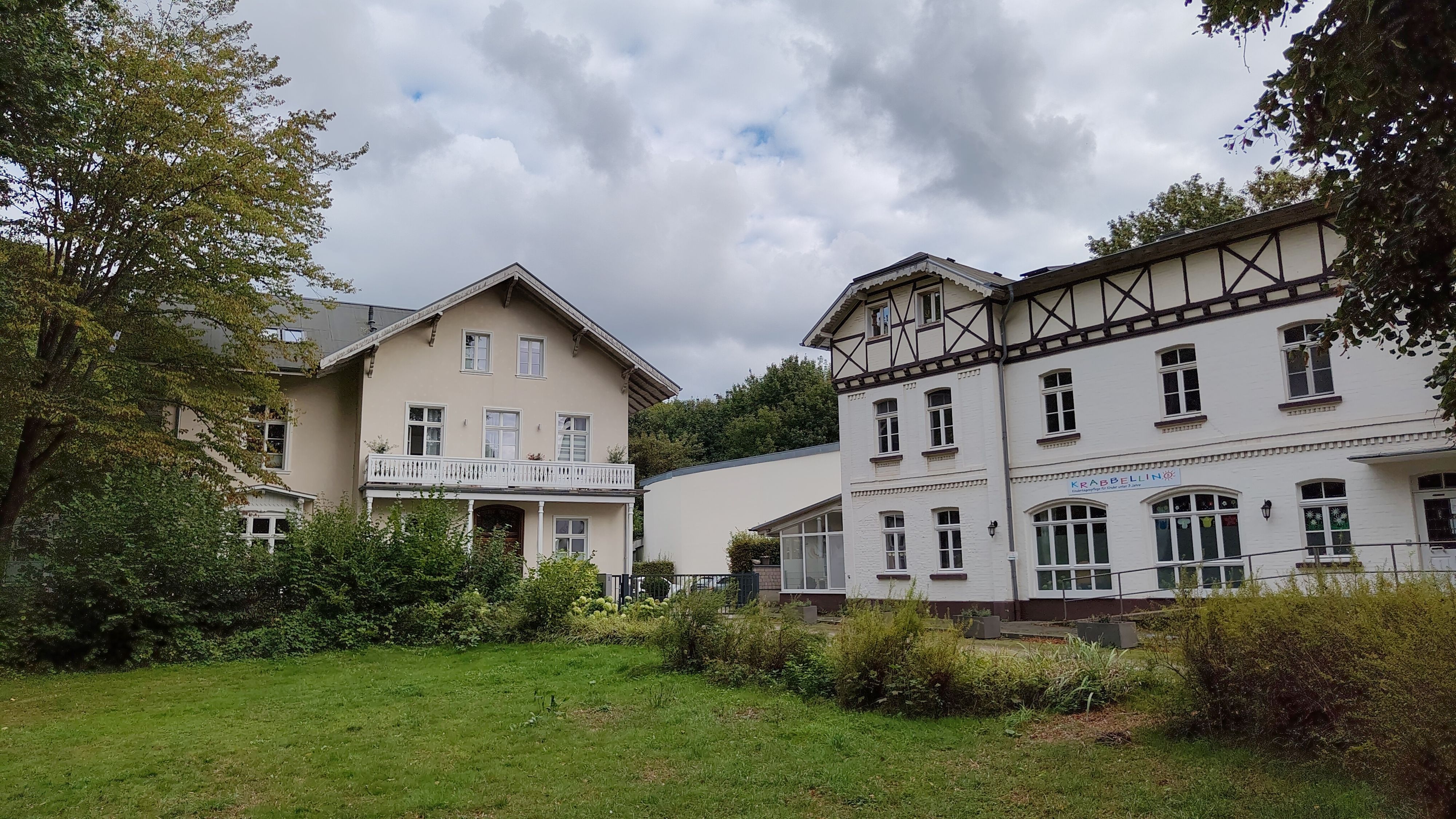 Es ist eine große Villa mit Nebengebäude zu sehen.