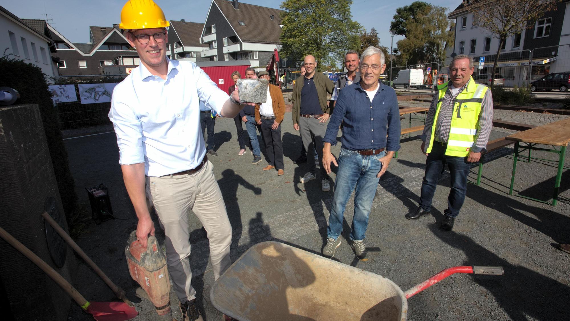 Das Foto zeigt Bürgermeister Sebastian Heimes (l.) mit einem Granitstein, der später wieder verwendet werden soll.