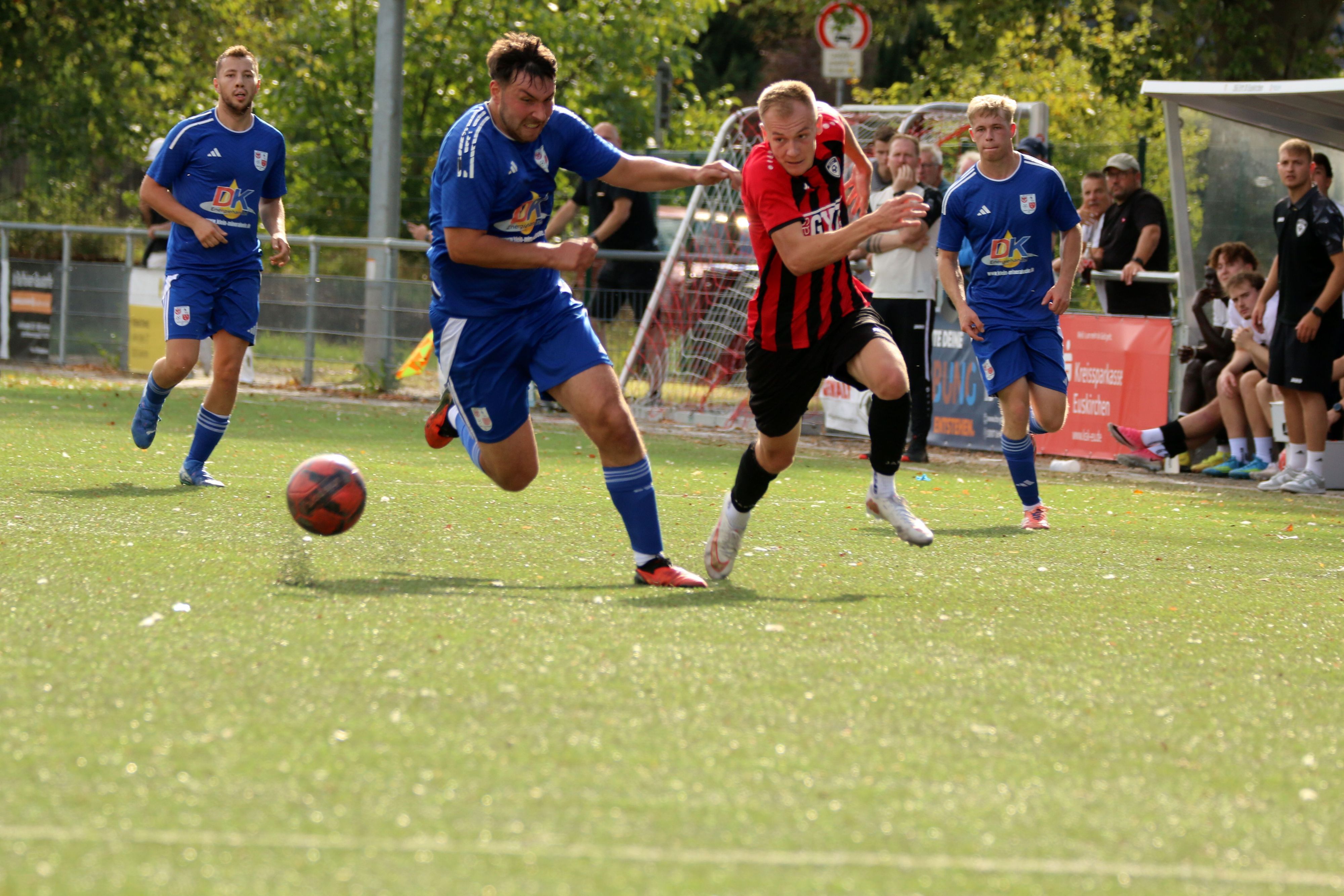 Zwei Fußballer befinden sich in einem intensiven Laufduell.