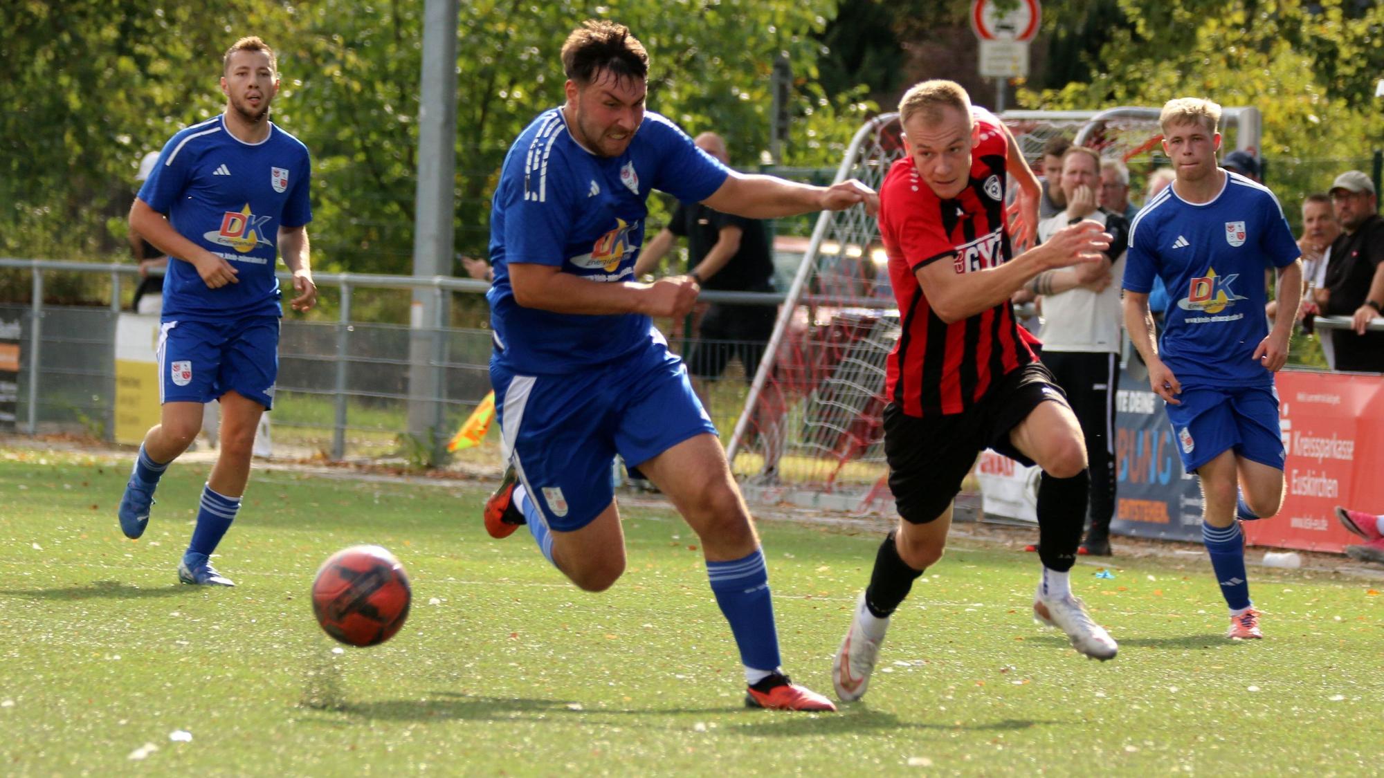 Zwei Fußballer befinden sich in einem intensiven Laufduell.