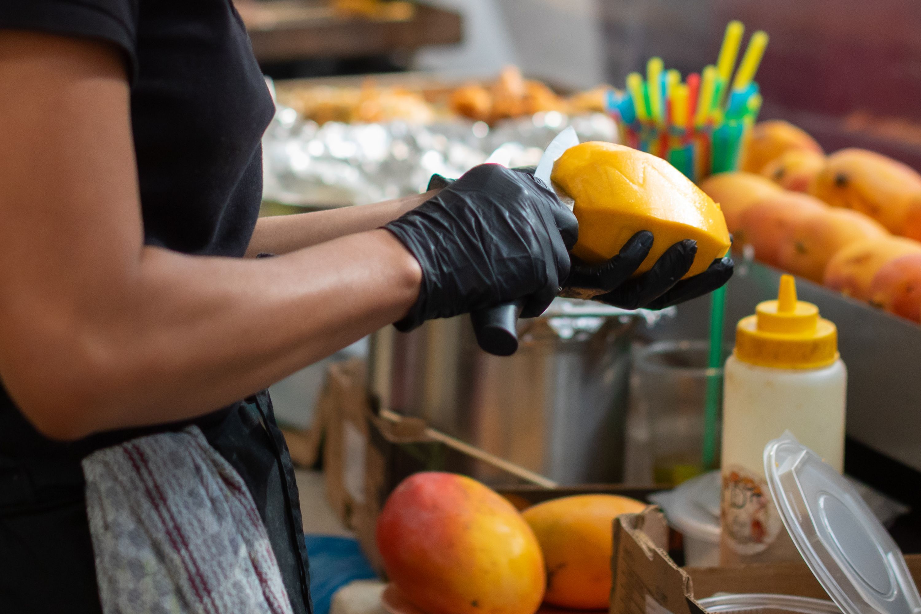 Eine Person schält eine Mango.