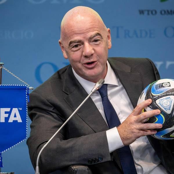 Bei einer Pressekonferenz hält Gianni Infantino einen Ball in der Hand.