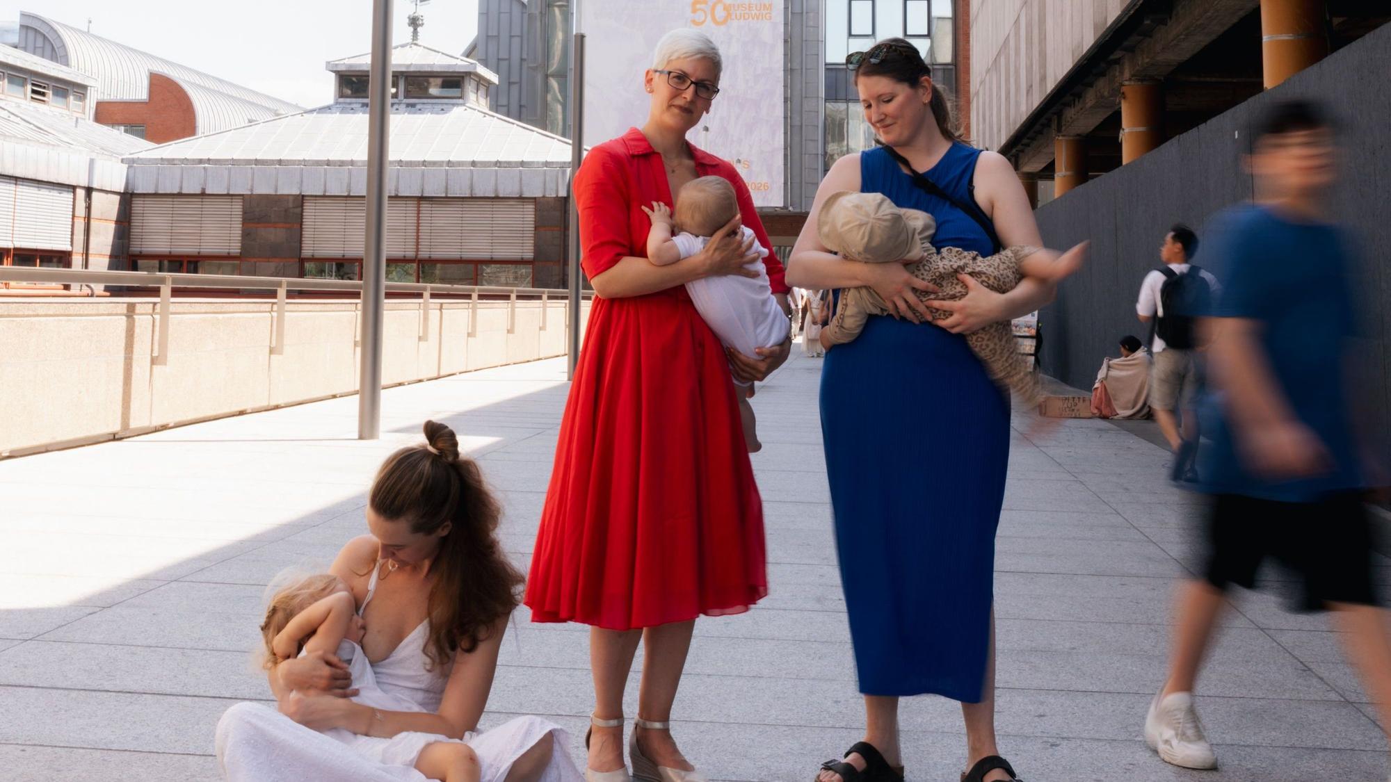 Drei Frauen stillen nahe des Museum Ludwig ihre Kinder.