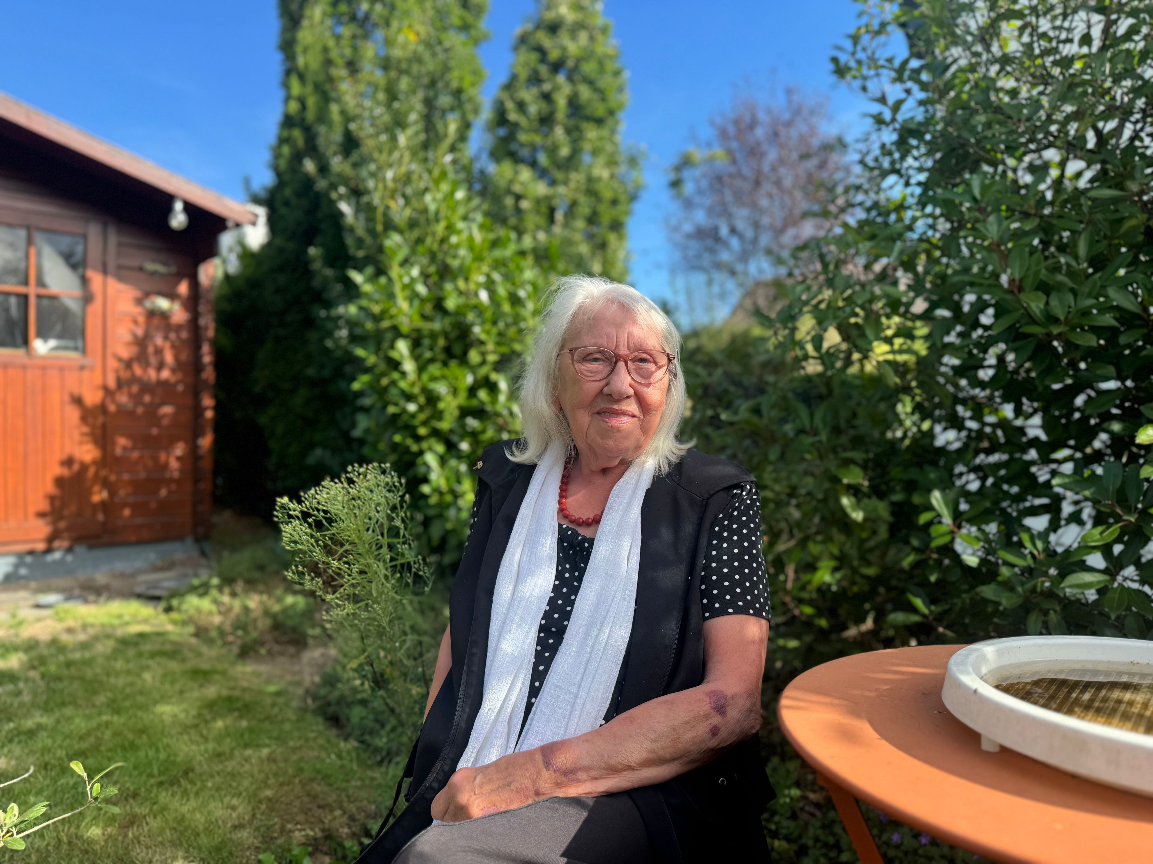 Helga sitzt in ihrem Garten
