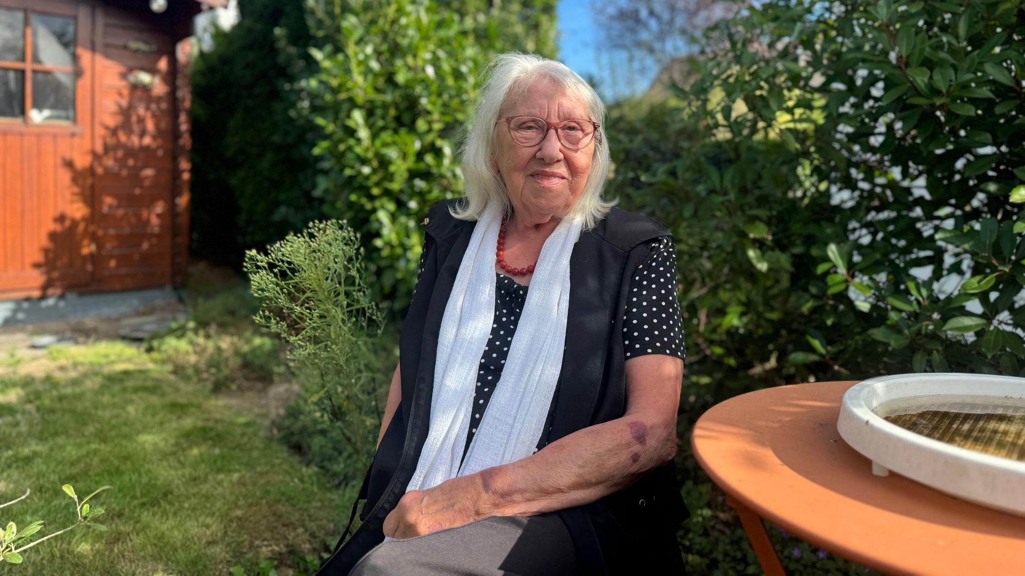 Helga sitzt in ihrem Garten
