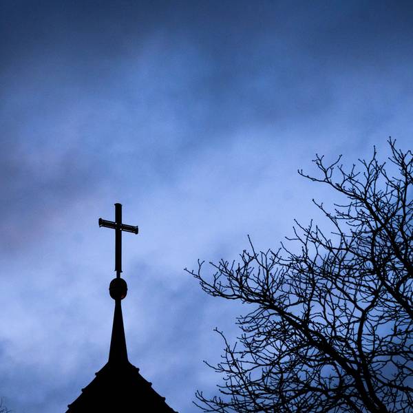 Dunkle Wolken ziehen über das Kreuz einer Kirche hinweg. (Symbolbild)