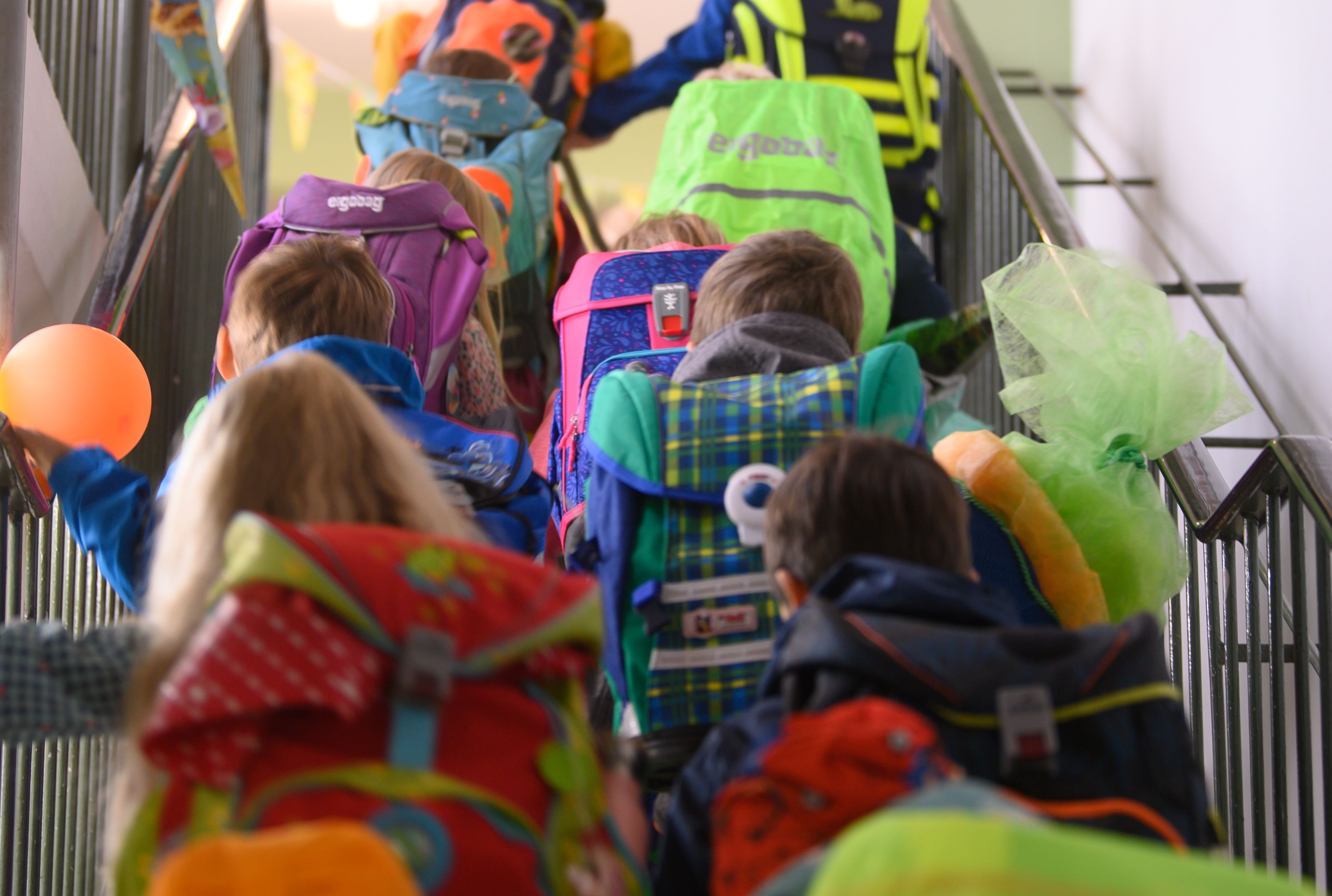 Grundschüler einer ersten Klasse begeben sich durchs Treppenhaus der Schule in ihr Klassenzimmer.