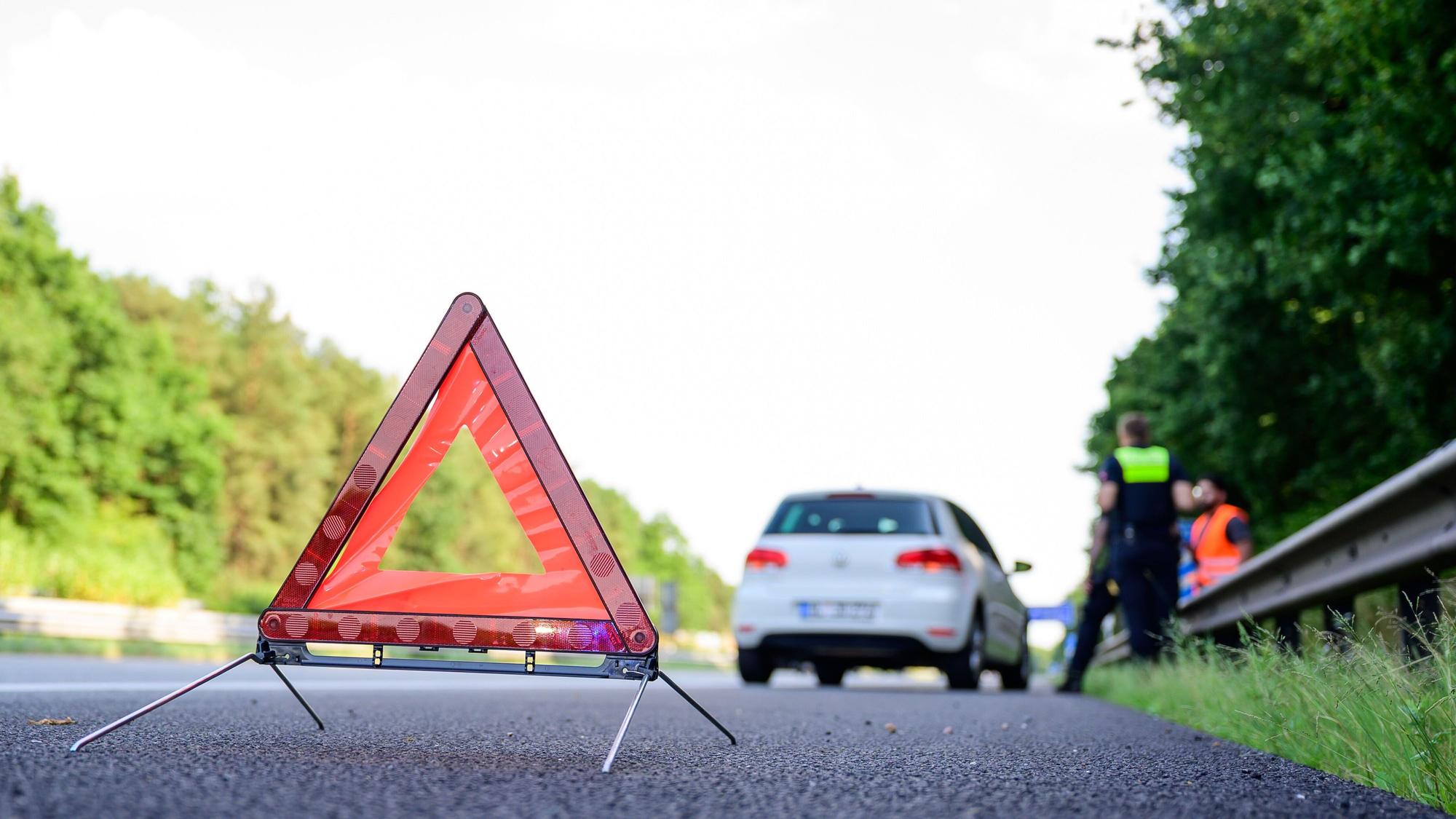 Ein Polizist nimmt einen Unfall auf einer Landstraße auf (Symbolfoto).