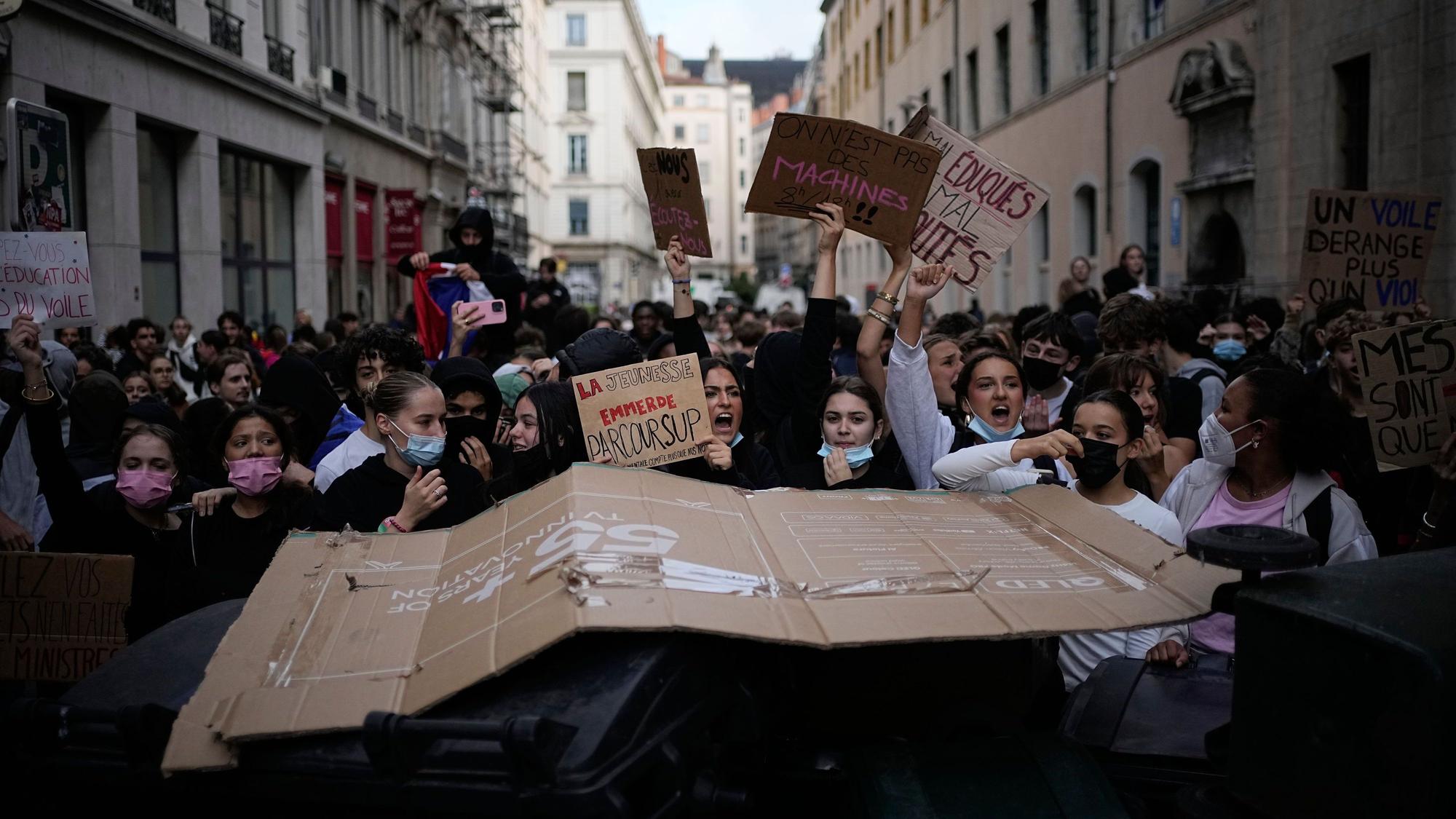 Schülerinnen und Schüler skandieren Parolen, während sie vor einer blockierten Oberschule gegen die mangelnde Ausstattung der Schulen protestieren.