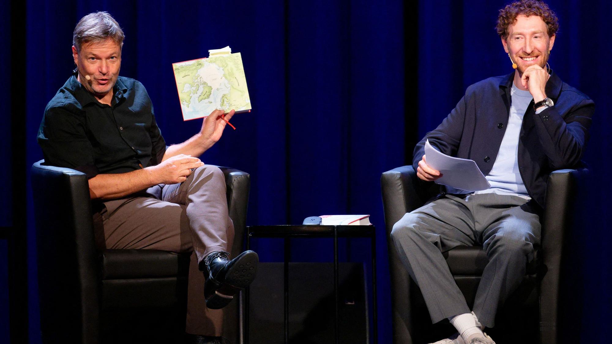 Robert Habeck (l.) und Moderator Louis Klamroth sitzen bei der Vorstellung von Habecks neuem Buch im Rahmen der LitCologne auf der Bühne.