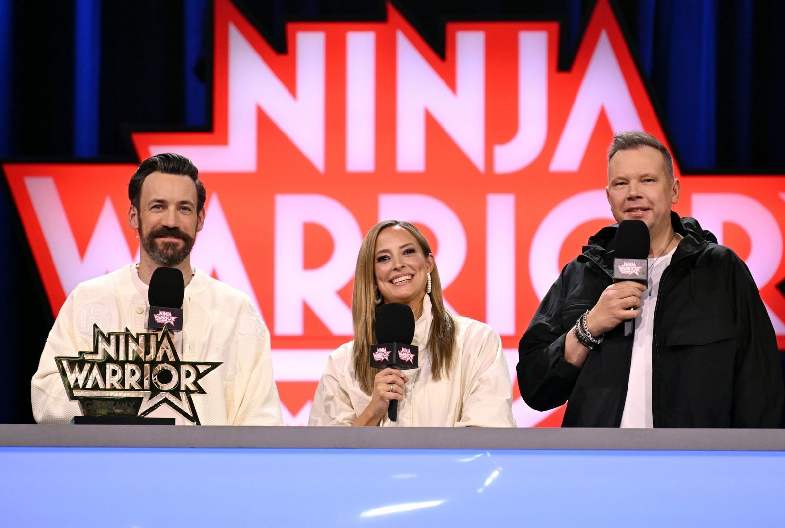Mit „Spaß in den Backen“ und mächtig Volldampf rein in die elfte Staffel von „Ninja Warrior Germany“ (RTL): Urgestein Jan Köppen (rechts) mit seinen neuen Moderations-Kollegen Anna Fleischhauer und Wolff Fuss. (Bild: RTL/Markus Hertrich)