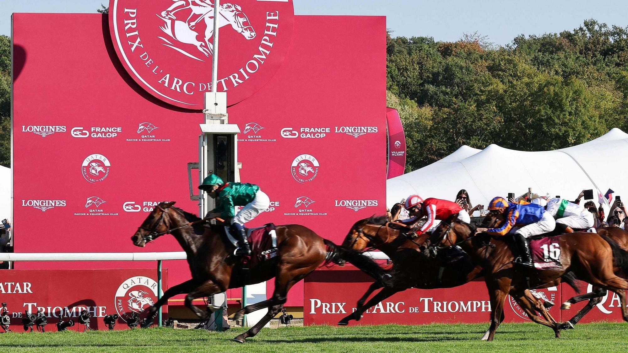 French jockey Mickael Barzalona riding Daryz (L) crosses the finish line to win the Qatar Prix de l'Arc de Triomphe horse race at the Longchamp race course, in Paris on October 4, 2026. (Photo by MEHDI FEDOUACH / AFP)