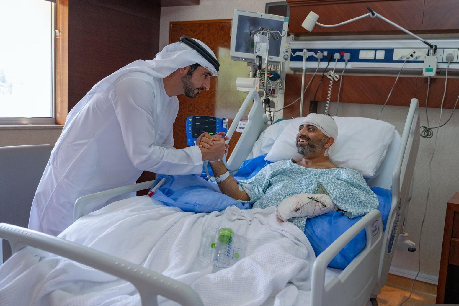 Auf diesem Foto, das vom Medienbüro der Regierung von Dubai zur Verfügung gestellt wurde, besucht der Kronprinz von Dubai, Scheich Hamdan bin Mohammed bin Rashid Al Maktoum (l.), den verletzten indischen Flydubai-Kapitän Smit Machchhar in einem Krankenhaus in Abu Dhabi.