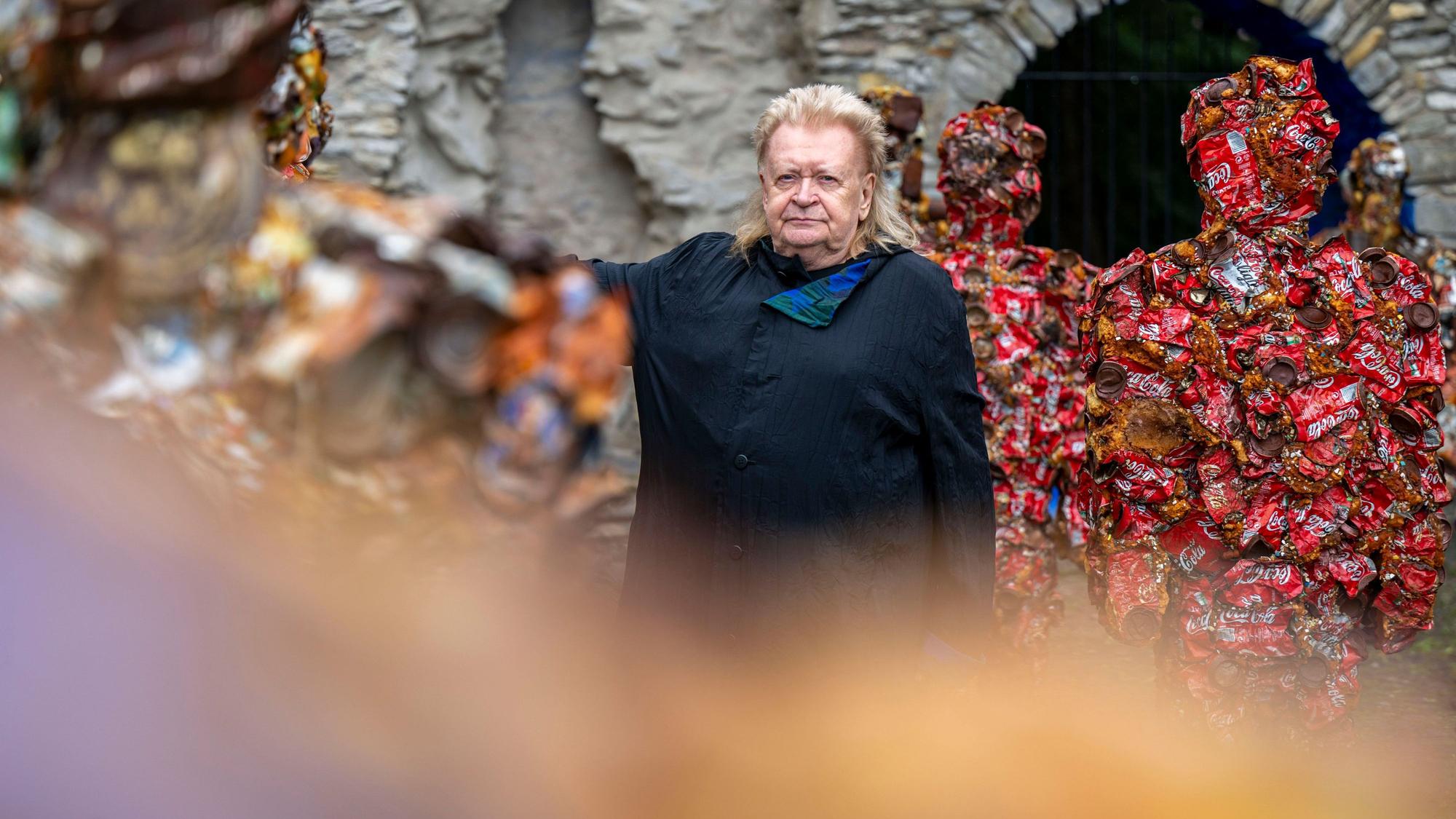 Der Künstler Hans-Jürgen Schult steht an seiner Installation Trash People aus Müll.