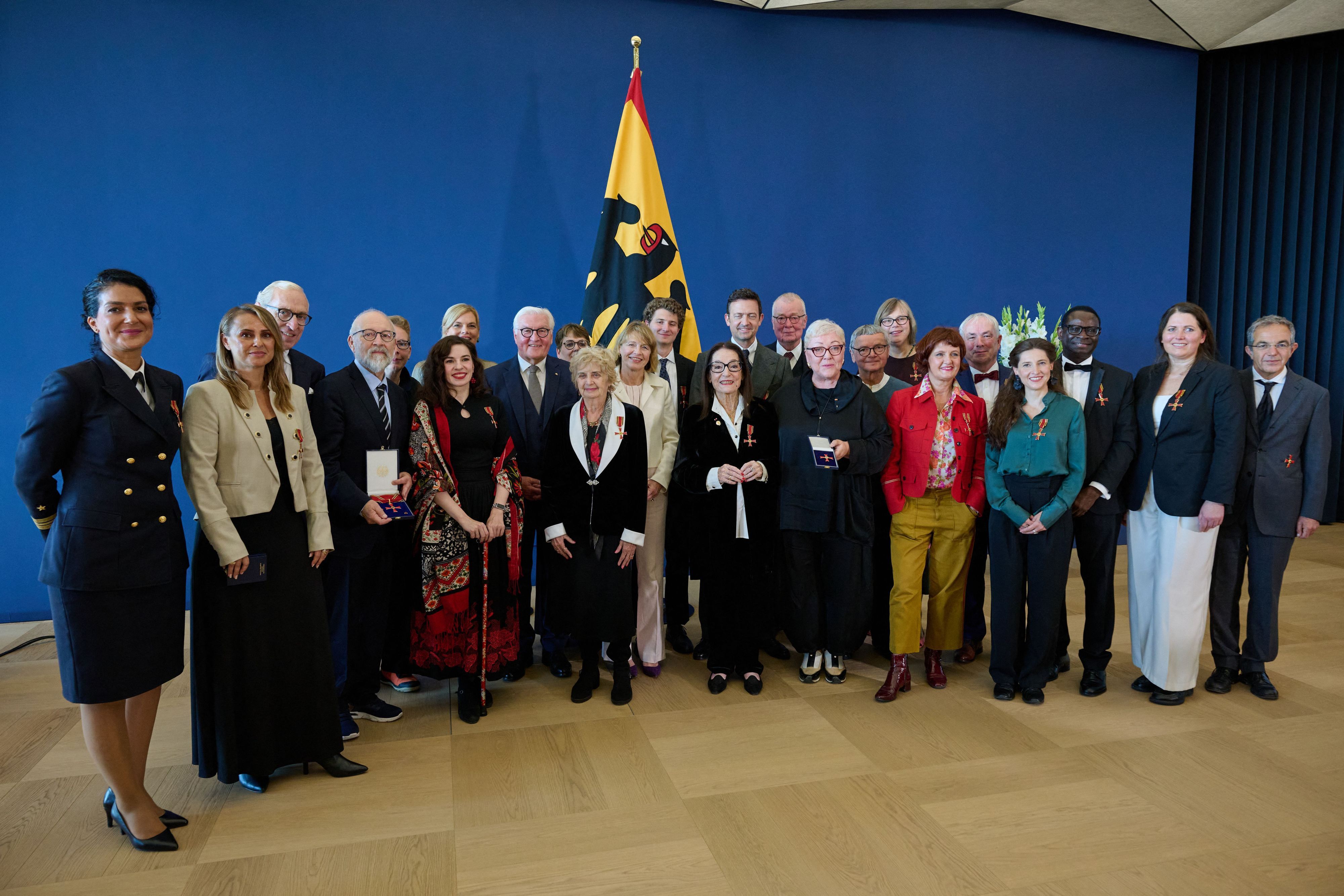 05.10.2026, Berlin: Bundespräsident Frank-Walter Steinmeier (8.v.l.) und seine Frau Elke Büdenbender (M) stehen zusammen mit Bundestagspräsidentin Julia Klöckner (7.v.l., CDU) und den Geehrten nach der Verleihung von Verdienstorden der Bundesrepublik Deutschland zum Tag der Deutschen Einheit im Amtssitz am Spreebogen für ein Gruppenbild zusammen. Die geehrten zwölf Frauen und neun Männer setzen sich unter anderem für demokratische Werte und die Aussöhnung internationaler Verständigung ein und tragen teils als Künstler aktiv zum Zusammenhalt bei. Foto: Bernd von Jutrczenka/dpa +++ dpa-Bildfunk +++