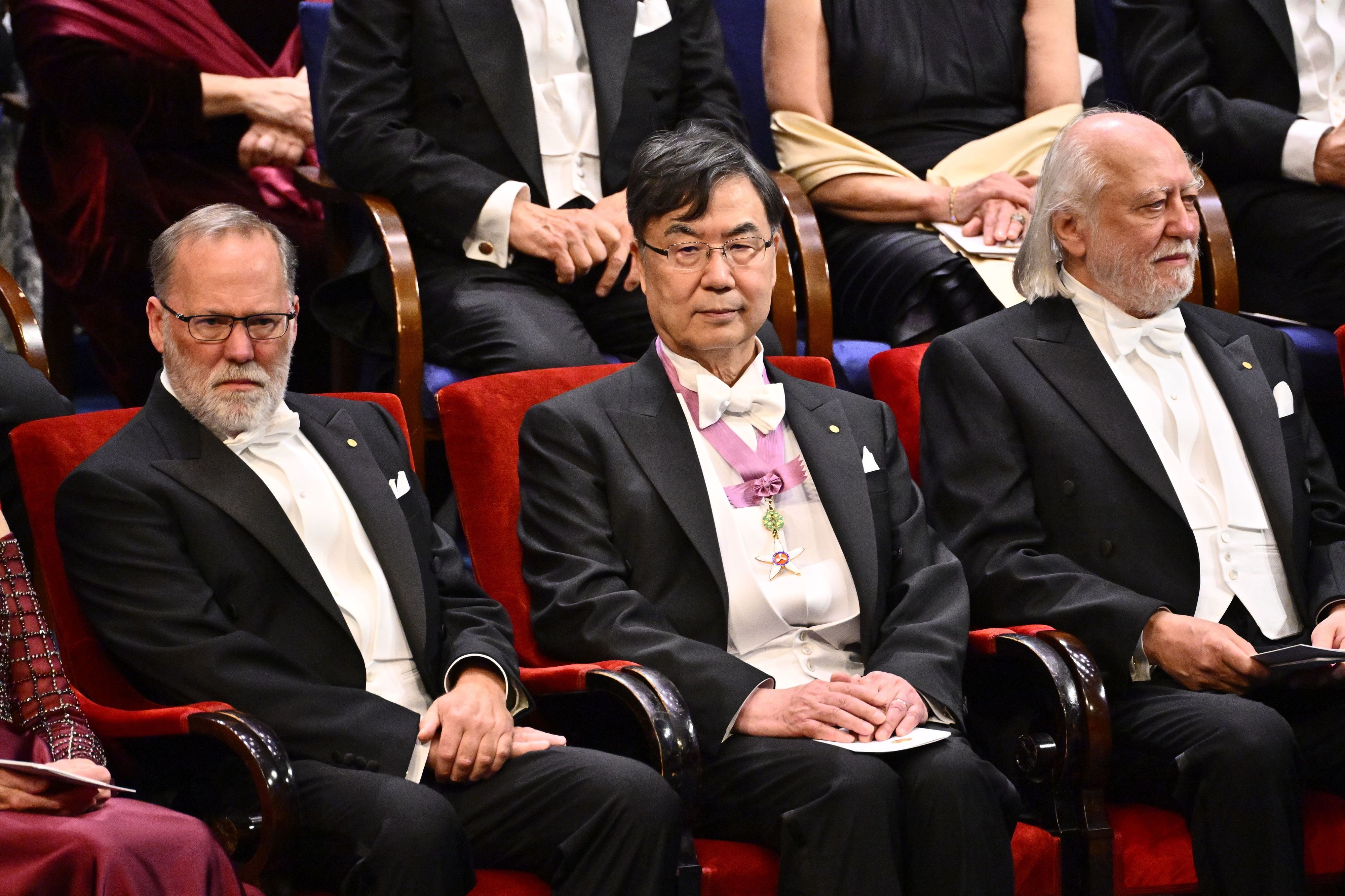Die Nobelpreisträger für Physiologie oder Medizin Fred Ramsdell (l) und Shimon Sakaguchi sitzen 2025 neben dem Literaturnobelpreisträger László Krasznahorkai (r) während der Nobelpreisverleihung in der Stockholmer Konzerthalle (Archivbild)