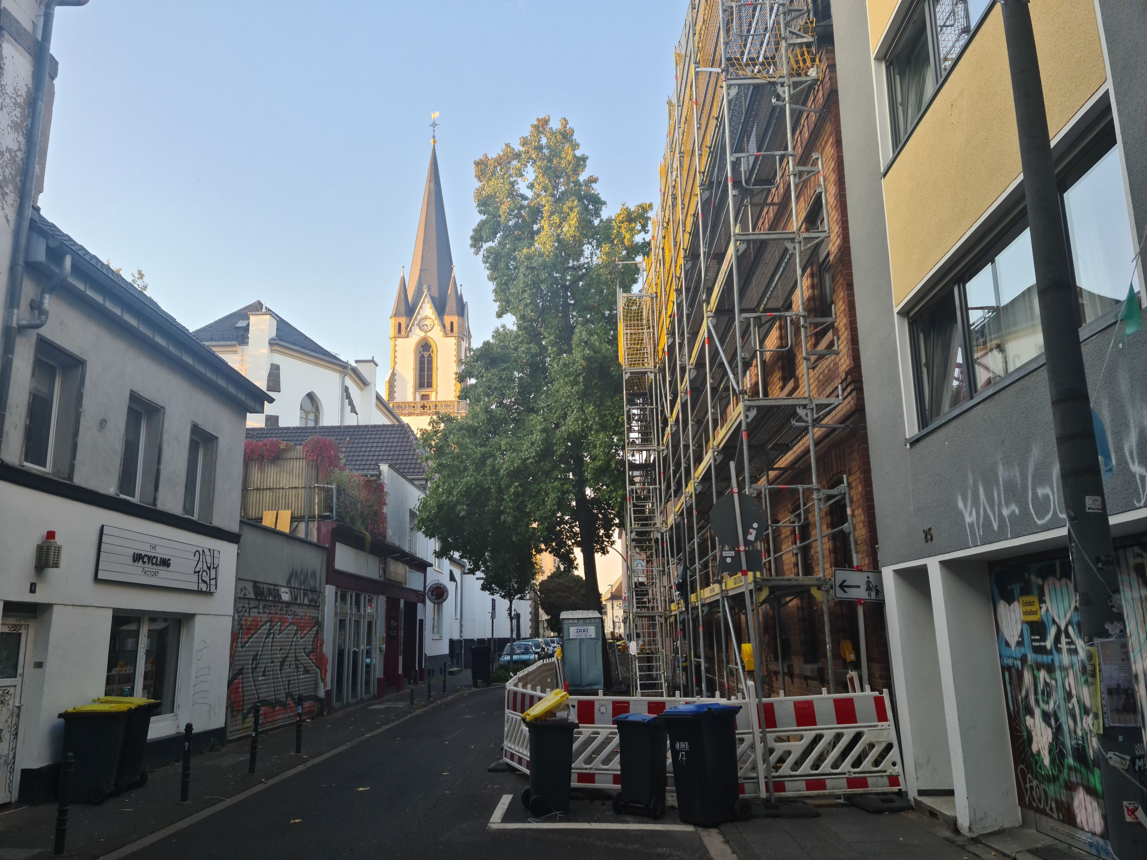 Eine Hausfassade in einer schmalen Straße ist eingerüstet.