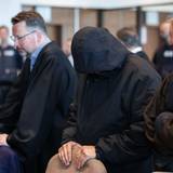 Köln: Ein Angeklagter steht neben den Verteidigern im Gerichtssaal. Der Raubüberfall in einer Hürther Lagerhalle gilt als Auslöser einer massiven Gewaltspirale, die als „Kölner Drogenkrieg“ bekannt wurde.