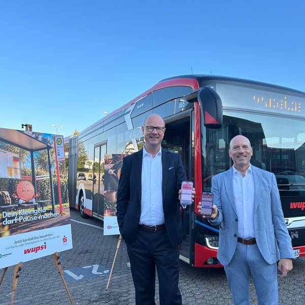 Marc Kretkowski und Markus Grawe stehen vor einem Bus.