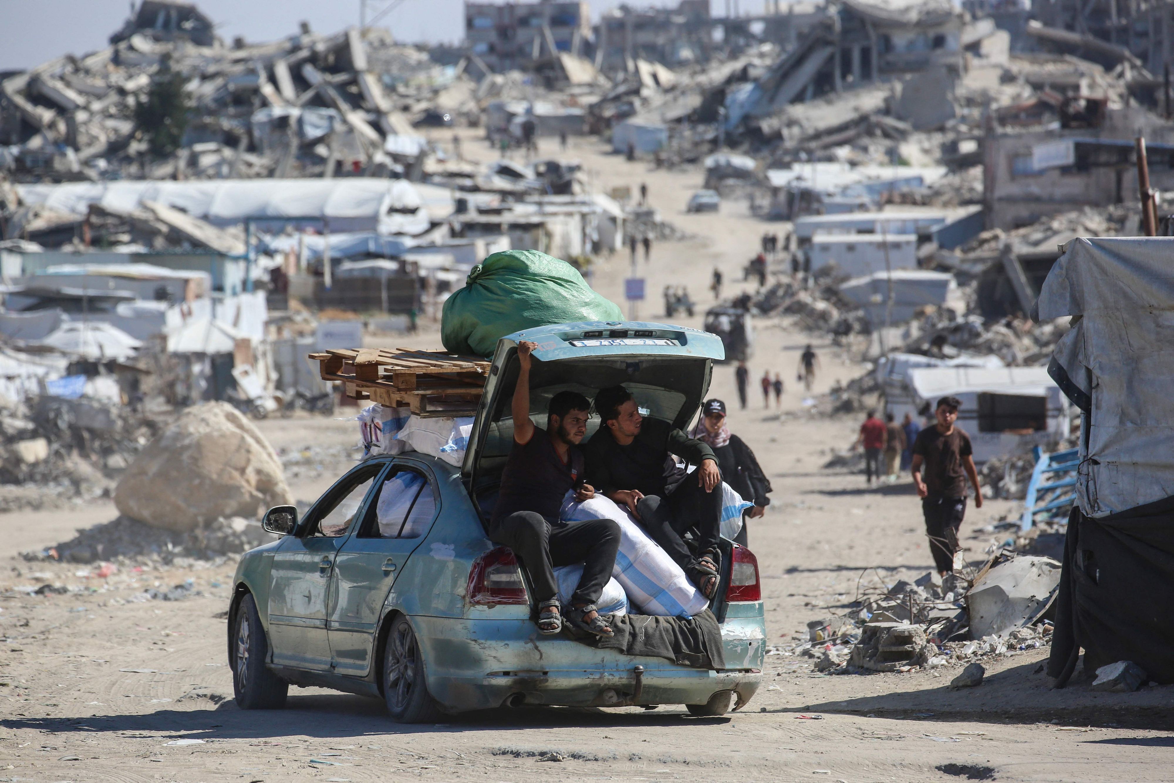 Palästinenser fahren mit einem mit Habseligkeiten beladenen Auto durch das zerstörte Flüchtlingslager Dschabalija im Norden des Gazastreifens.