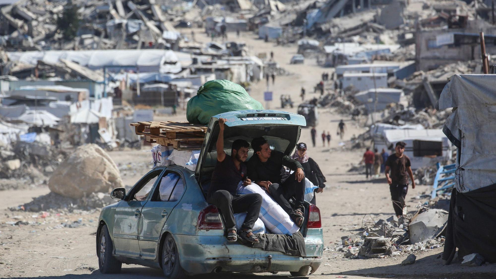 Palästinenser fahren mit einem mit Habseligkeiten beladenen Auto durch das zerstörte Flüchtlingslager Dschabalija im Norden des Gazastreifens.