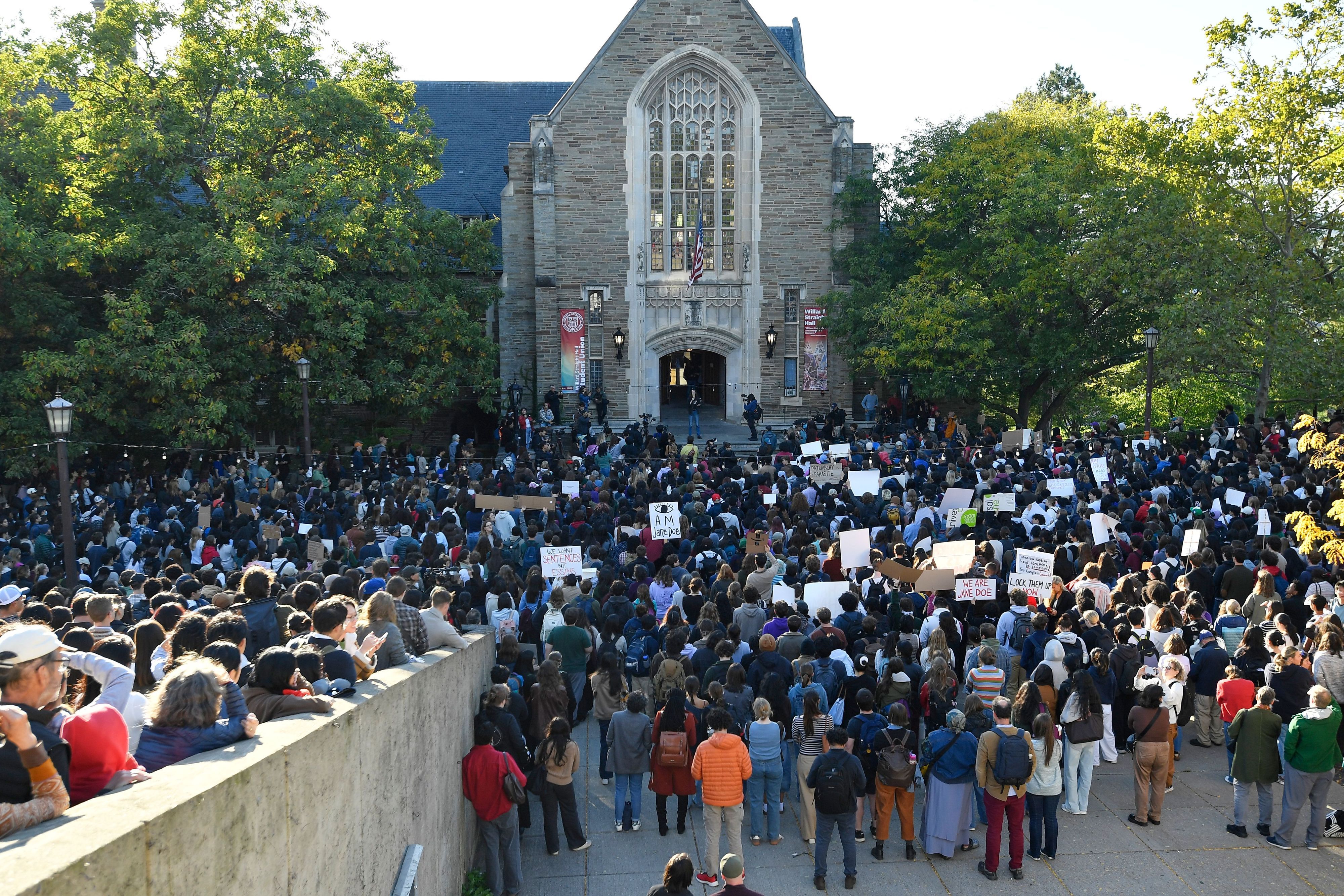 Demonstrierende lauschen einem Redner während einer Protestkundgebung gegen den Umgang der Cornell University mit den Vorwürfen einer Gruppenvergewaltigung in einem Verbindungshaus auf dem Campus im Jahr 2024.