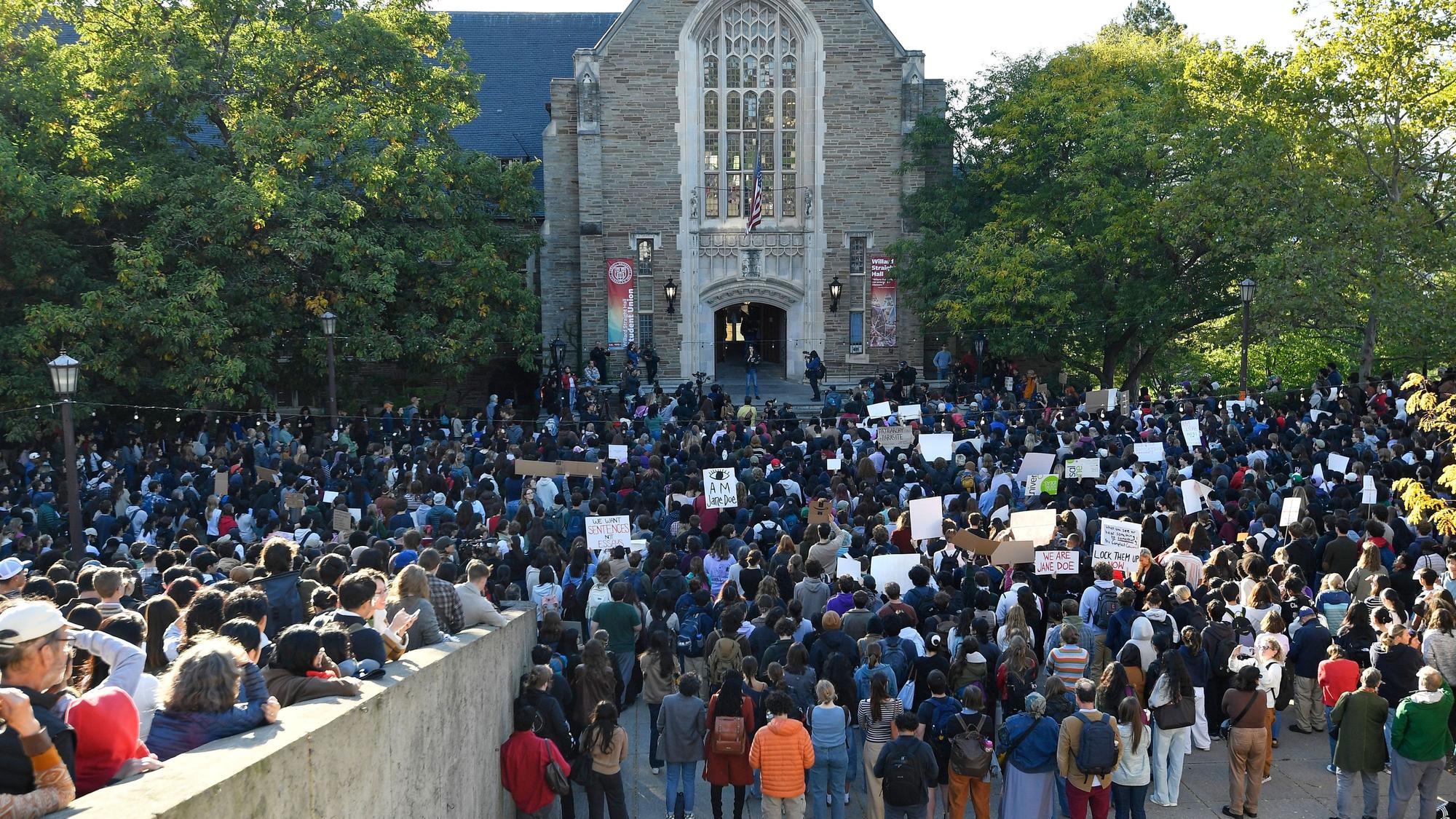 Demonstrierende lauschen einem Redner während einer Protestkundgebung gegen den Umgang der Cornell University mit den Vorwürfen einer Gruppenvergewaltigung in einem Verbindungshaus auf dem Campus im Jahr 2024.