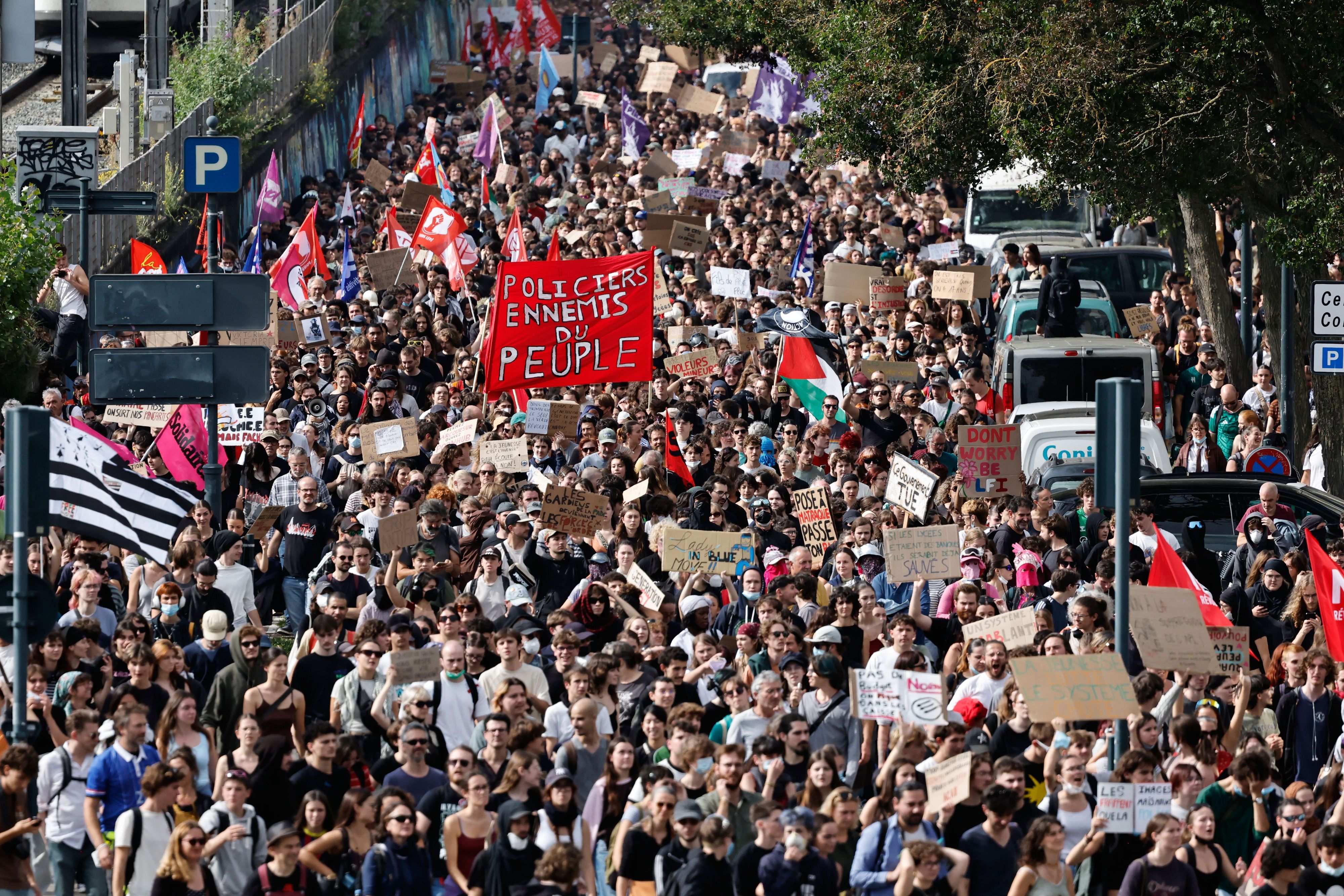 Studierende mit einem großen roten Transparent mit der Aufschrift „Polizisten, Feinde des Volkes“ marschieren in Rennes im Westen Frankreichs bei einer Demonstration gegen unterfinanzierte Schulen.