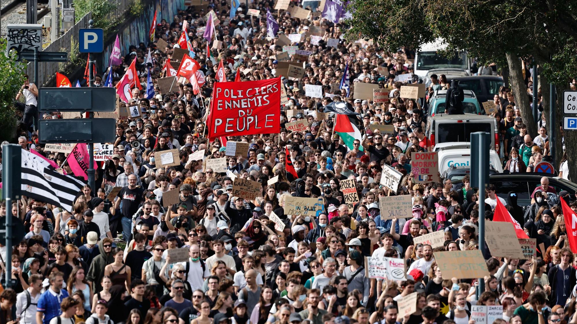 Studierende mit einem großen roten Transparent mit der Aufschrift „Polizisten, Feinde des Volkes“ marschieren in Rennes im Westen Frankreichs bei einer Demonstration gegen unterfinanzierte Schulen.