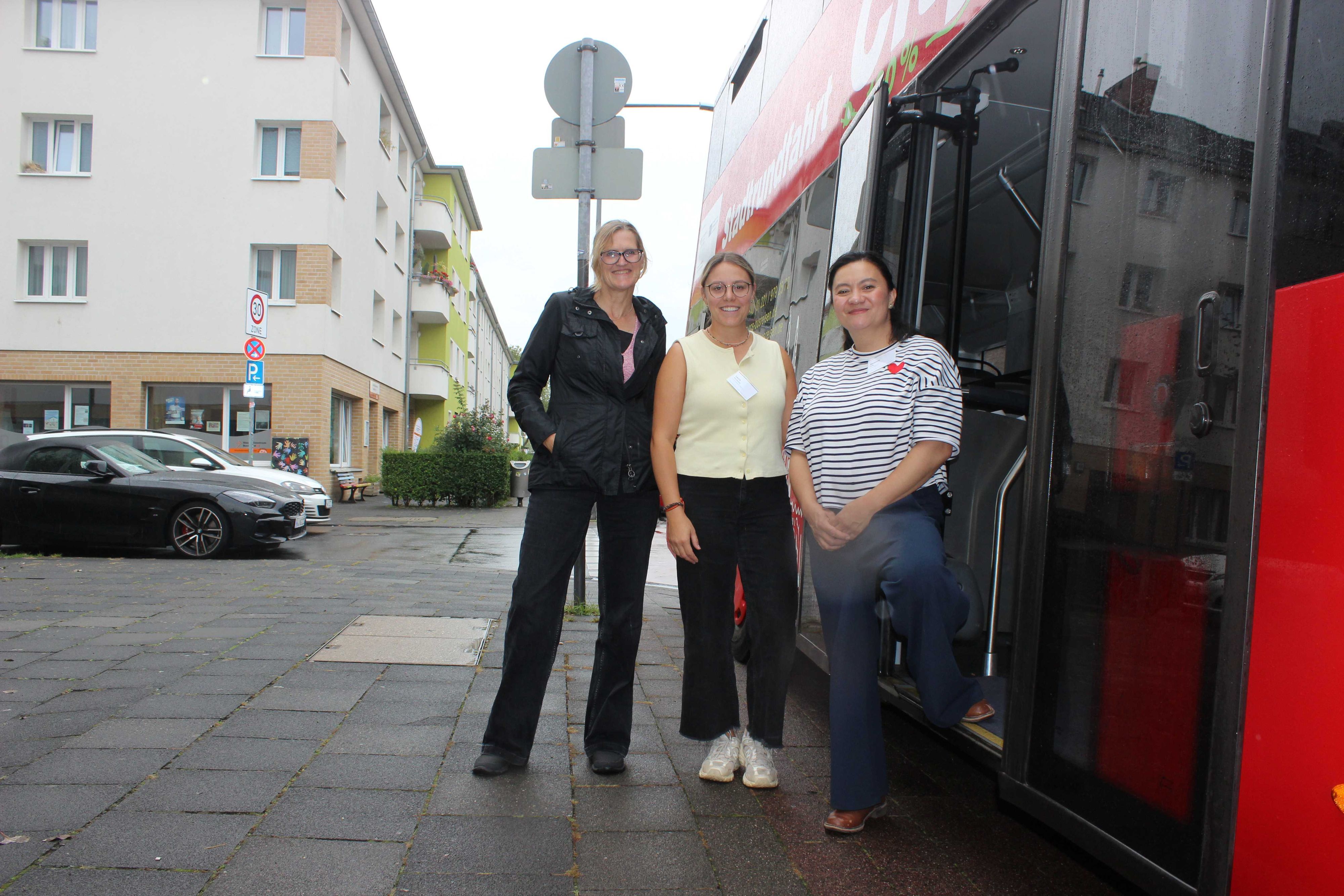 Organisatorin Elizaveta Khan (rechts) zusammen mit Birgit Werning (links) und Laura dos Santos vom Amt für Integration und Vielfalt während der Bustour zu Interkulturellen Zentren.