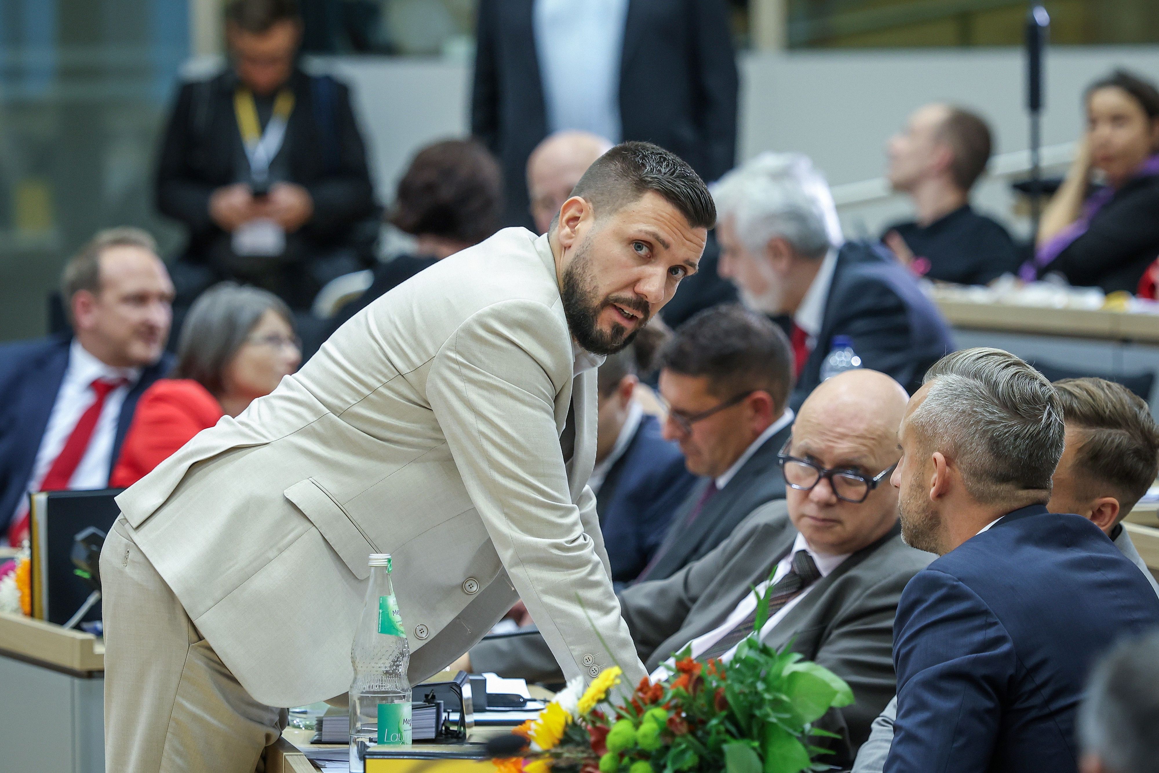 Der neu gewählte Landtagspräsident Tobias Rausch (l, AfD) unterhält sich während der konstituierenden Landtagssitzung in Sachsen-Anhalt mit Ulrich Siegmund (r,AfD) und anderen Parteikollegen.
