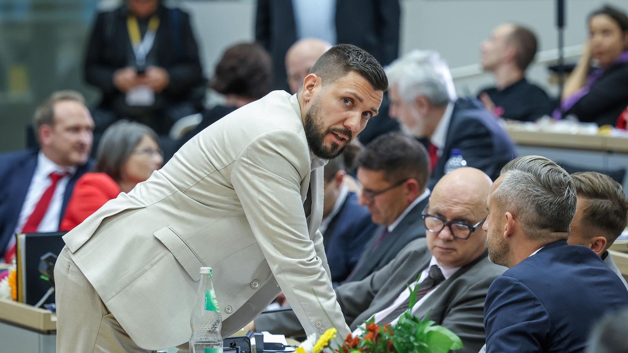 Der neu gewählte Landtagspräsident Tobias Rausch (l, AfD) unterhält sich während der konstituierenden Landtagssitzung in Sachsen-Anhalt mit Ulrich Siegmund (r,AfD) und anderen Parteikollegen.