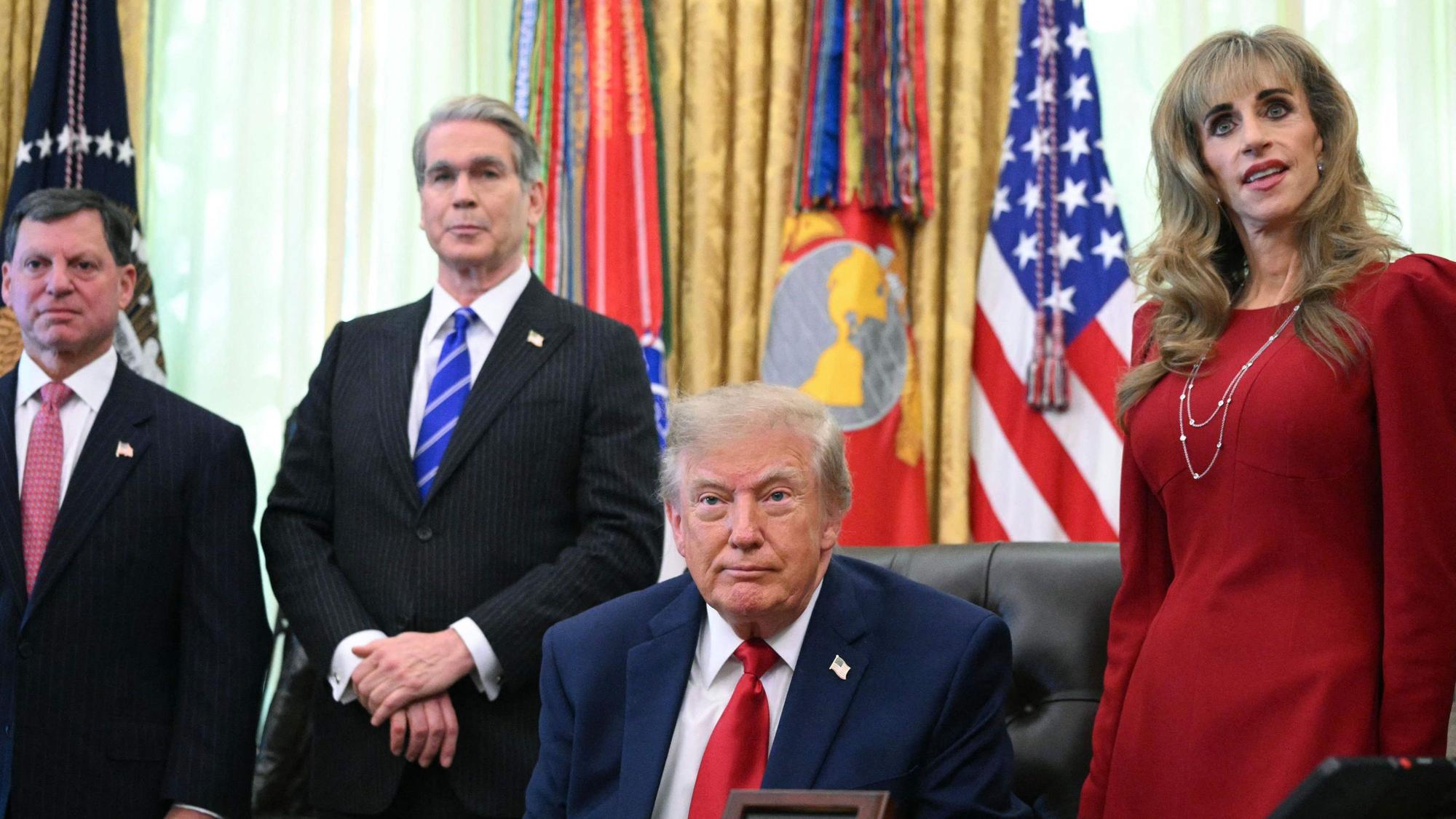 Susan Dell (r.) steht in einem roten Kostüm neben Donald Trump im Oval Office.