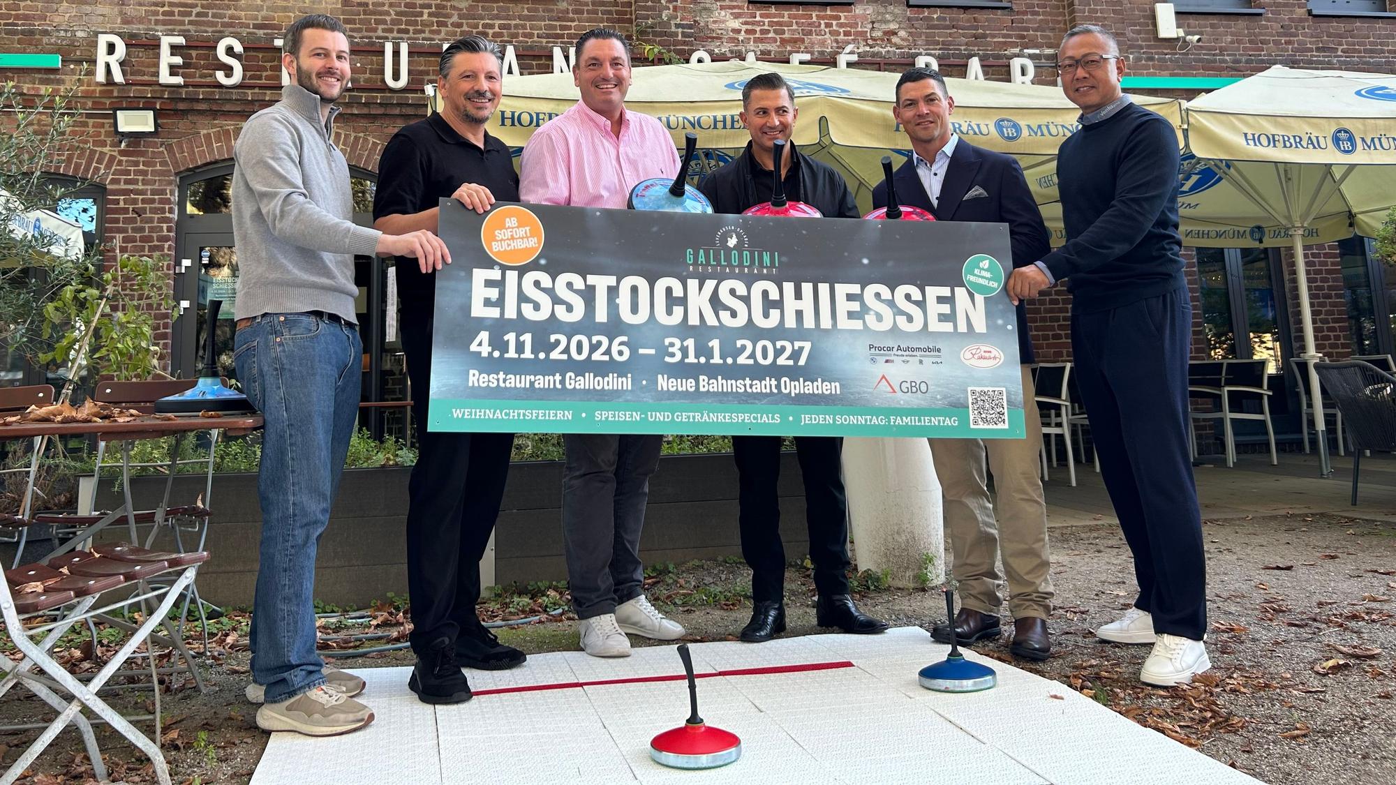 Sechs Männer halten ein Plakat hoch.