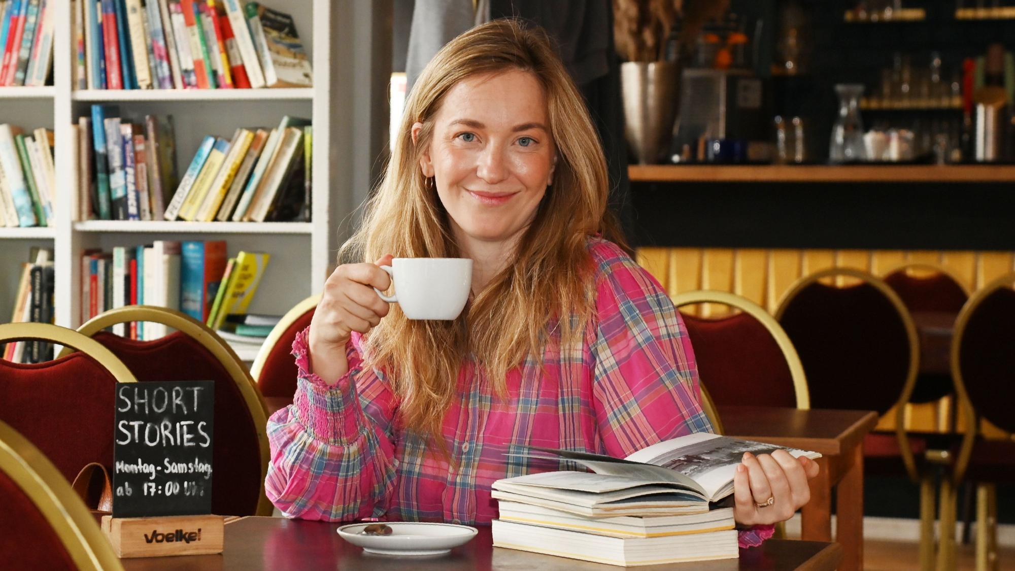 Johanna Flock mit Buch und Kaffee