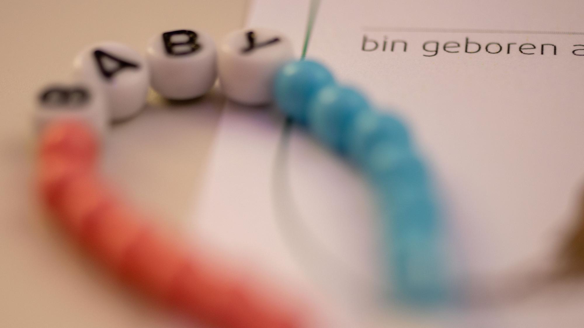 Ein Baby klammert sich an den Finger seiner Mutter.