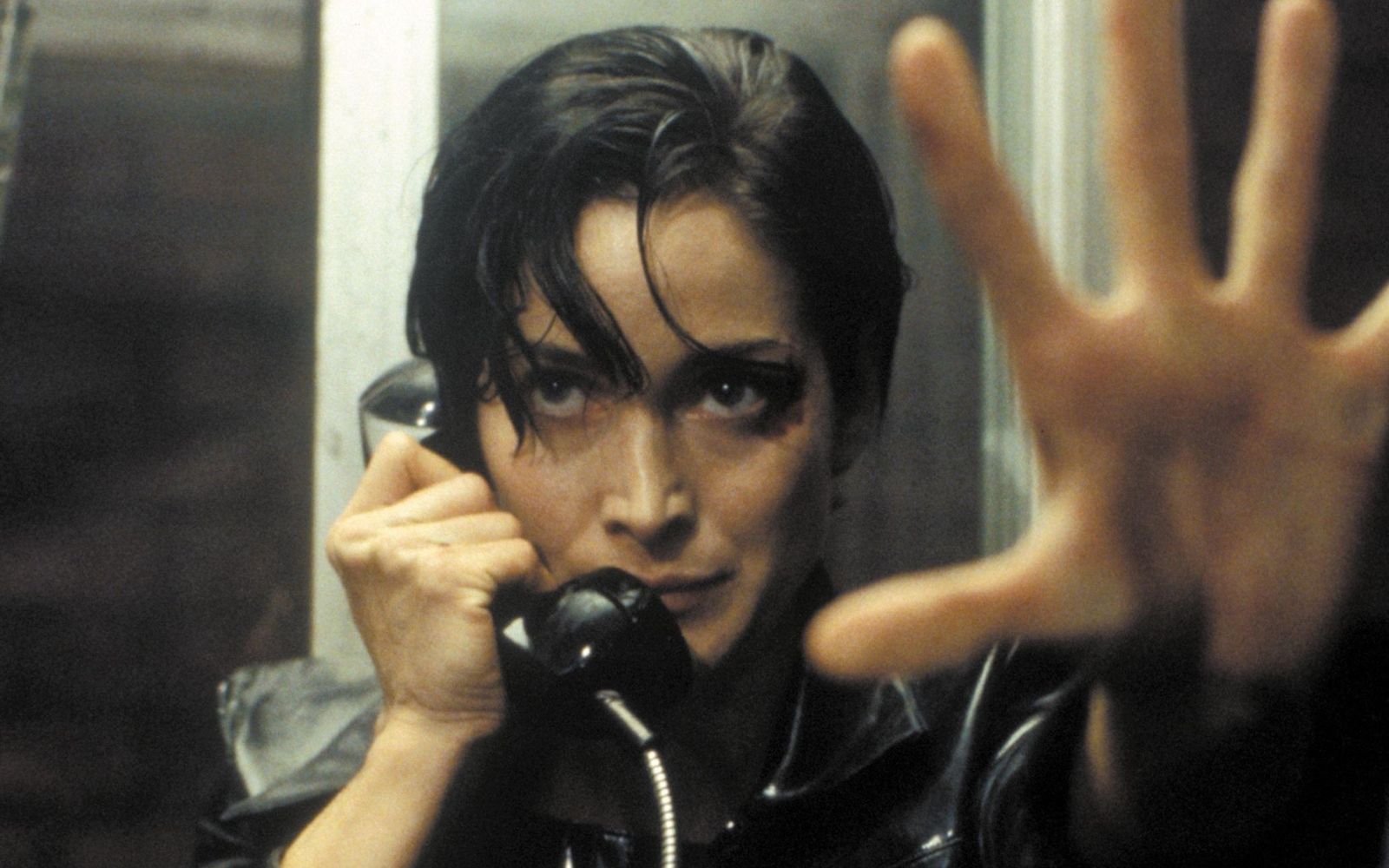 Trinity (Carrie-Anne Moss) nimmt den Ausgang aus der Matrix: eine öffentliche Telefonzelle. (Bild: RTL / 1999 Warner Bros. Entertainment Inc. )