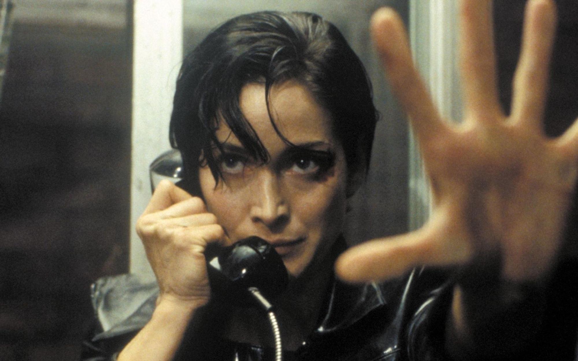 Trinity (Carrie-Anne Moss) nimmt den Ausgang aus der Matrix: eine öffentliche Telefonzelle. (Bild: RTL / 1999 Warner Bros. Entertainment Inc. )